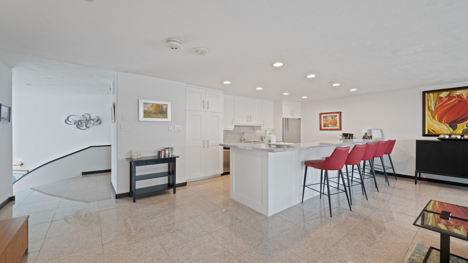 Gather around the stylish breakfast bar in your bright, modern kitchen, where sleek white cabinetry and gleaming countertops invite you to whip up meals and linger over morning coffee.