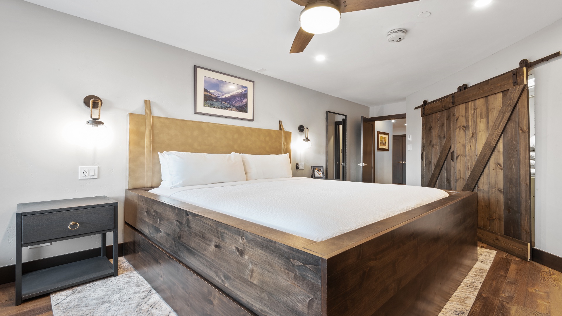 Sink into crisp linens and handcrafted wood furnishings in your serene bedroom retreat. The rustic barn door and warm accents create a cozy mountain escape perfect for unwinding after your adventures.