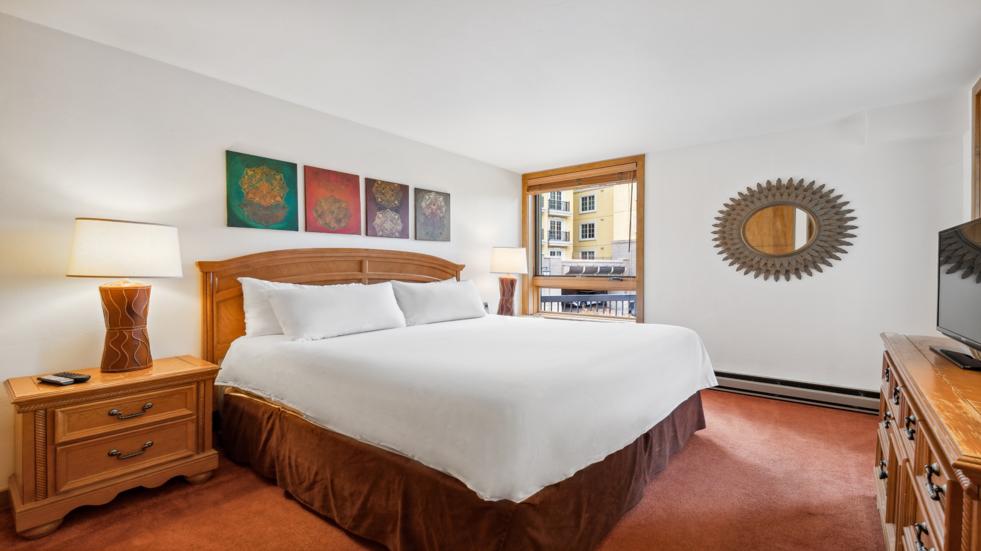 Sink into crisp linens and drift off in your cozy mountain retreat, where sunburst decor and vibrant artwork set a warm, welcoming tone for your stay.