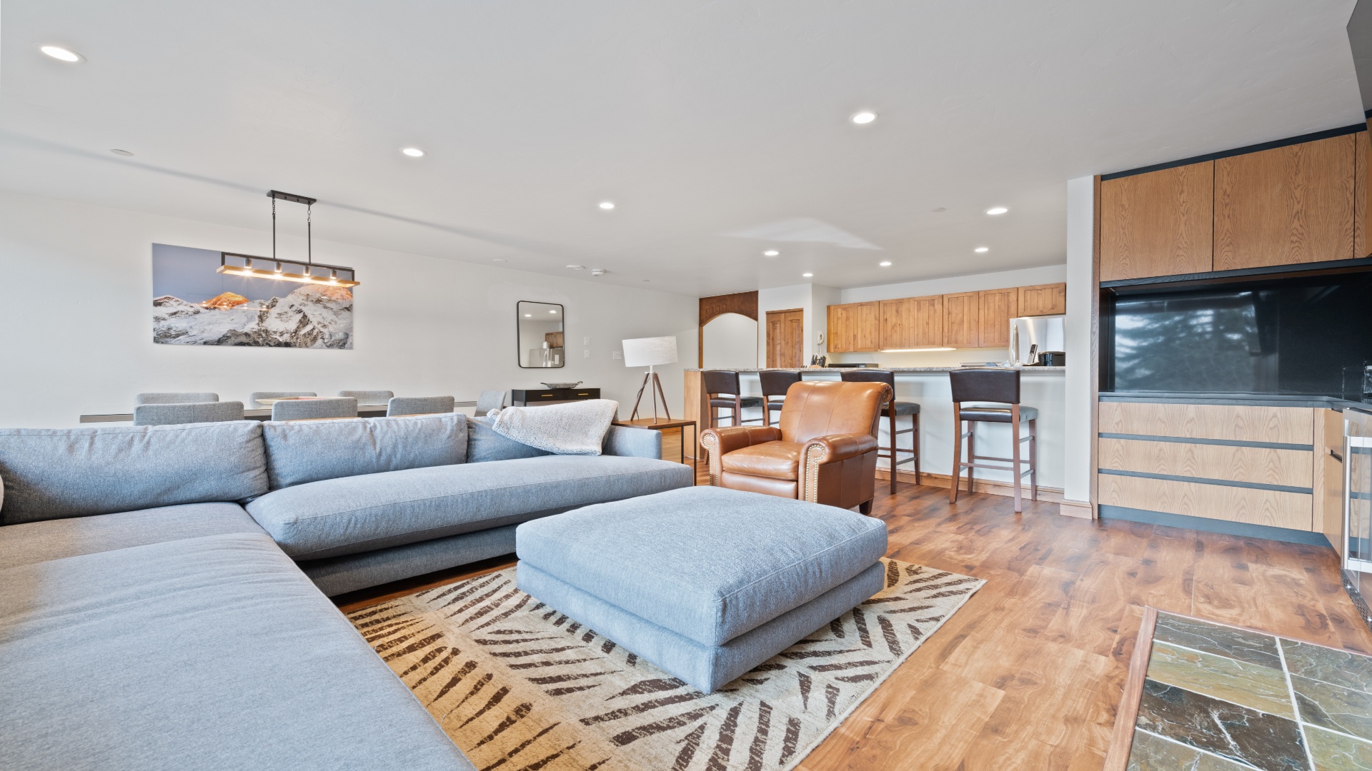 Unwind on plush seating in your open-concept living space, where modern style meets mountain charm. The fully-equipped kitchen and inviting dining area make gathering with loved ones effortless.