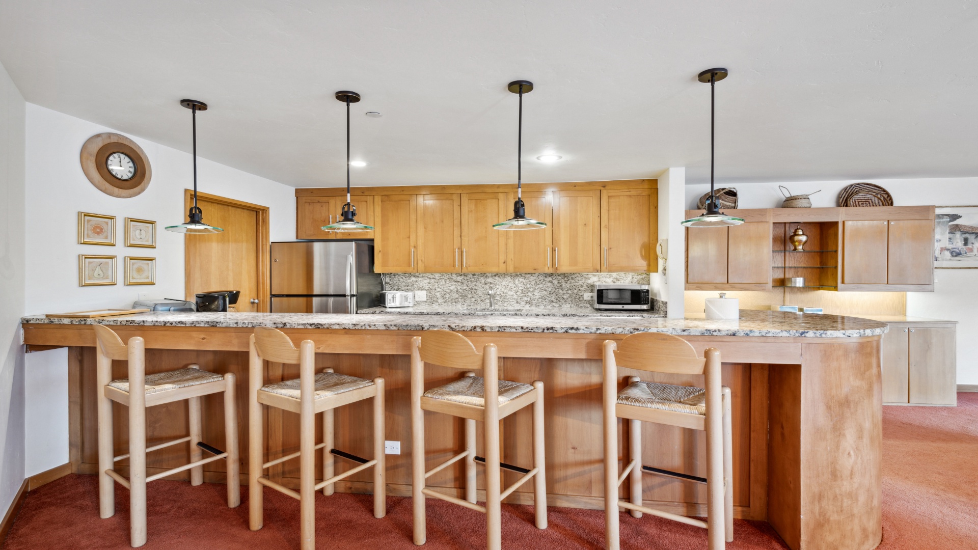 You'll love preparing meals in this welcoming kitchen, featuring warm wood cabinets, stylish pendant lighting, and a spacious granite island with seating for the whole group to gather.