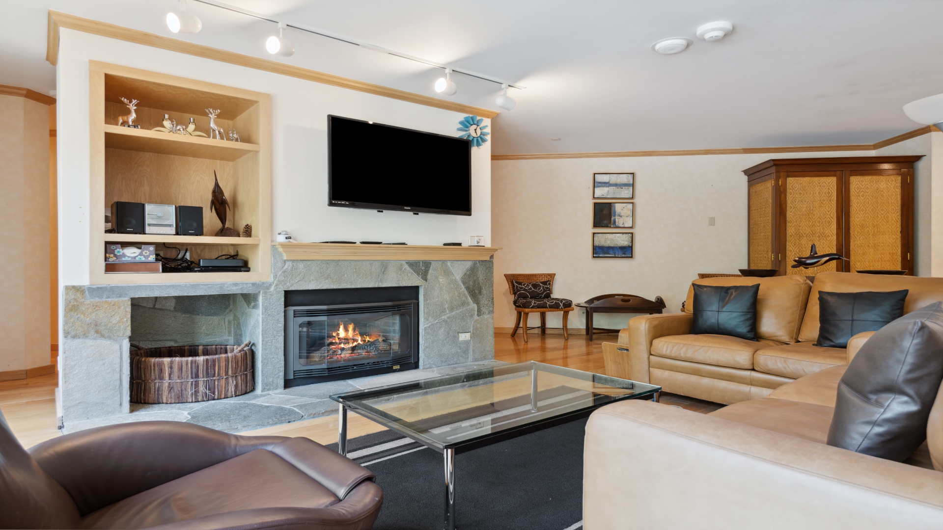 Settle into plush leather seating in your spacious living room, where a warm fireplace and modern entertainment system create the perfect retreat after a day of adventure.