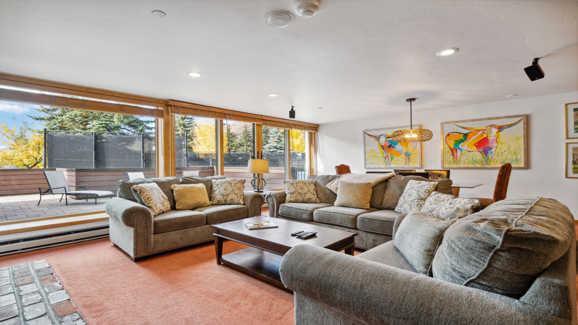 Sink into plush sofas surrounded by vibrant art and autumn views—your perfect spot to unwind and feel right at home.