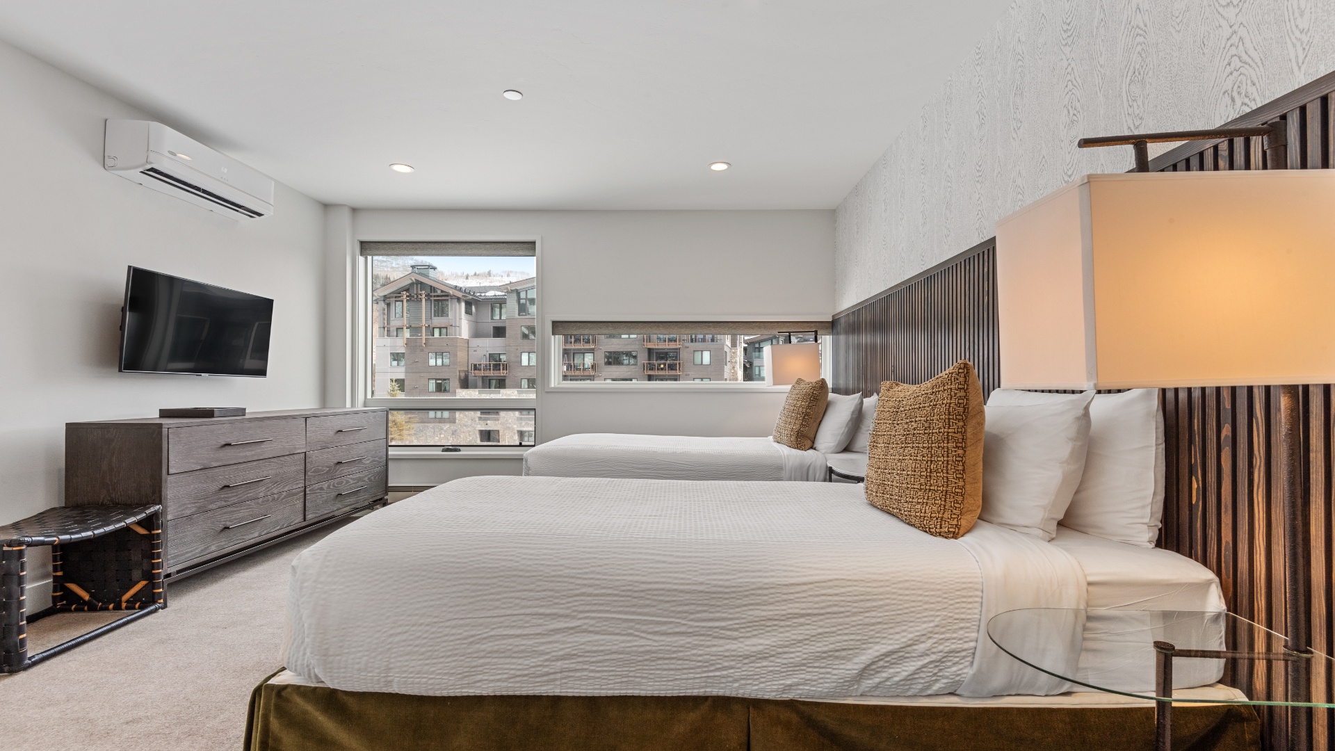 Unwind in your spacious bedroom, where two plush beds and modern comforts invite restful nights. Soft lighting and mountain views create a serene retreat after adventure-filled days.