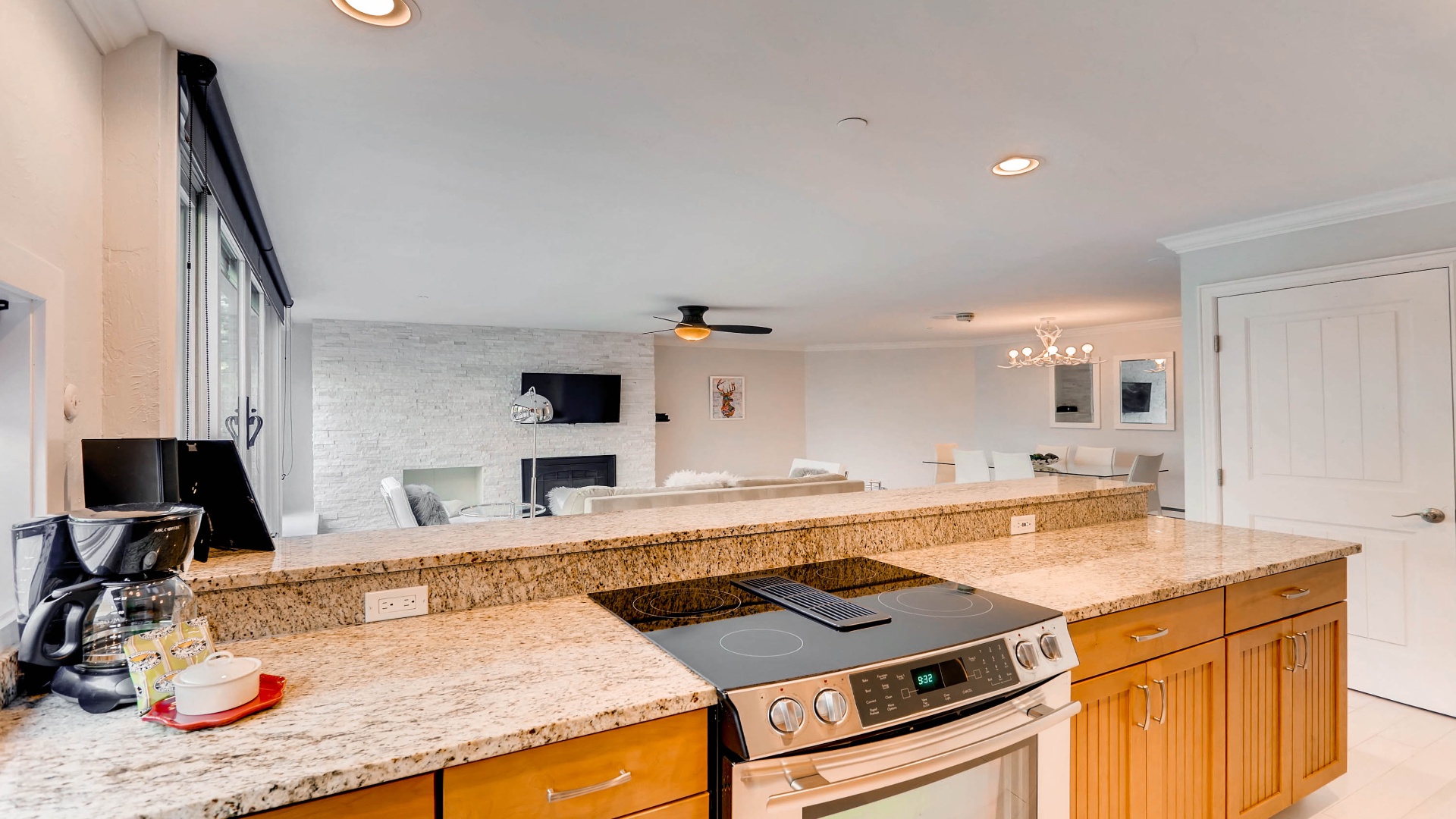 Your spacious kitchen features granite countertops and modern appliances, opening to a stylish living area with a cozy fireplace and plenty of natural light.