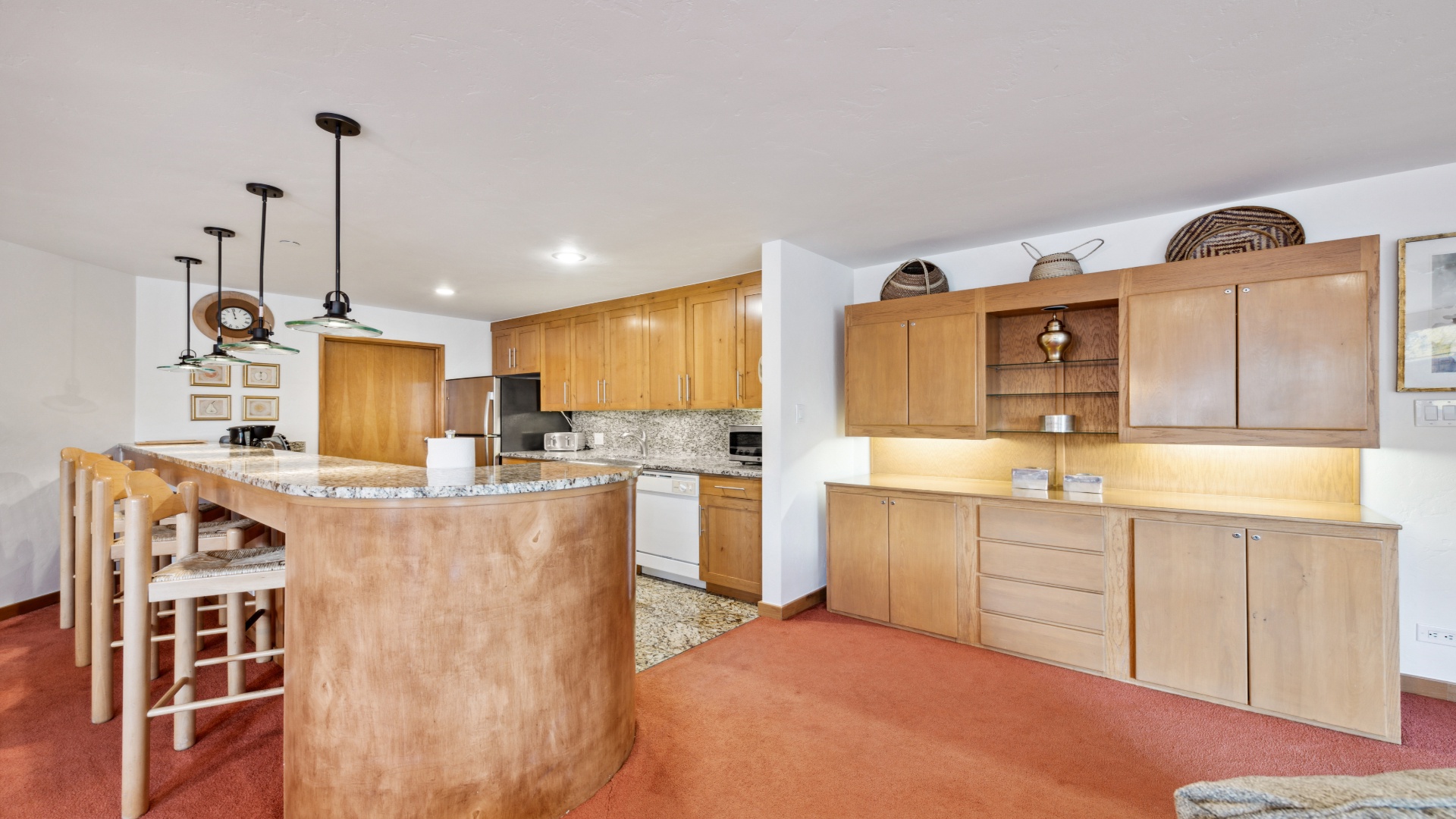 Your spacious kitchen features warm wood cabinetry, granite countertops, and a curved island with bar seating—perfect for preparing meals and gathering with loved ones.