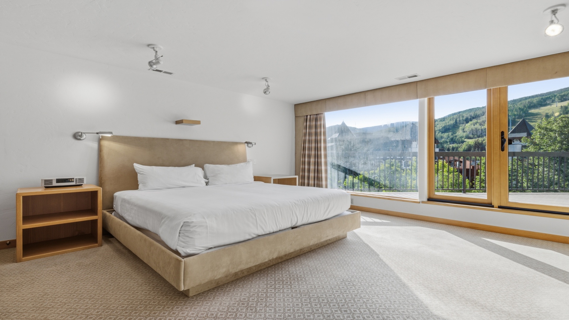 Wake up to stunning mountain views through floor-to-ceiling windows in your bright, modern bedroom. Crisp linens and minimalist design create a peaceful retreat where natural light floods in all day.