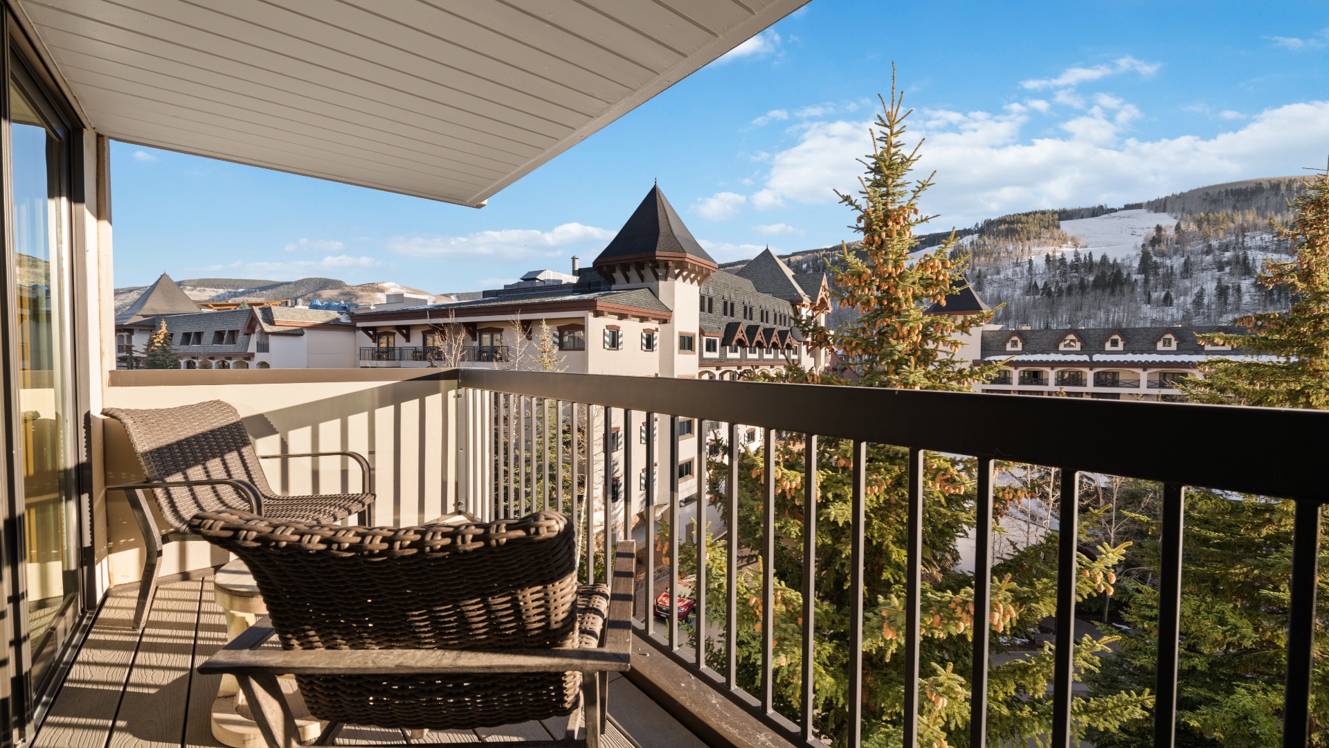 A private balcony overlooking ski village architecture and snow-dusted mountain slopes, where crisp alpine mornings meet stunning year-round mountain views.