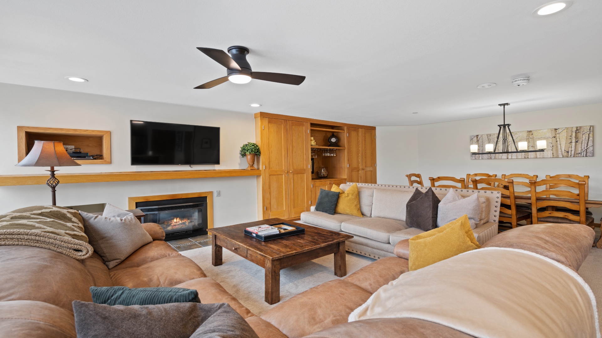 Unwind in this spacious living area with plush seating, a warm fireplace, and open-plan dining—perfect for gathering with your group after a day of adventure.