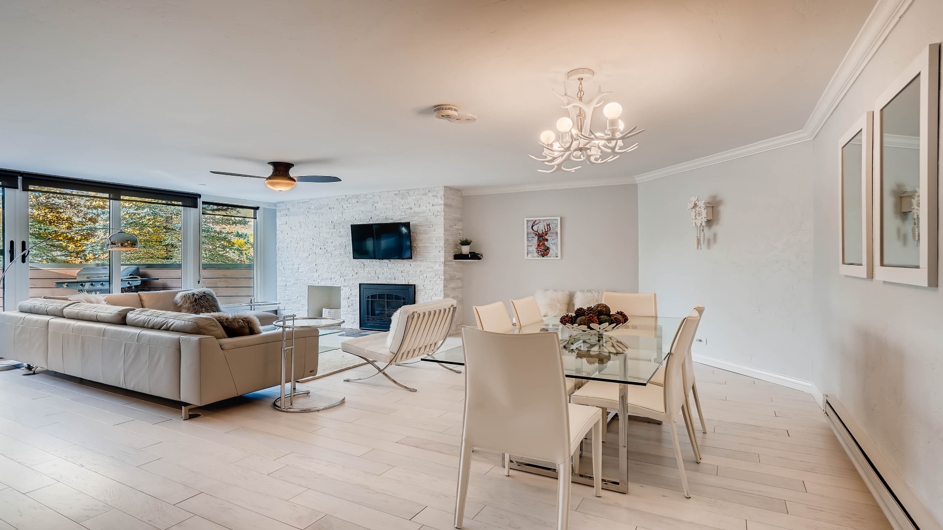 Relax in your open, sunlit living space with modern decor, plush seating, a cozy fireplace, and elegant dining area perfect for unwinding after exploring the area.