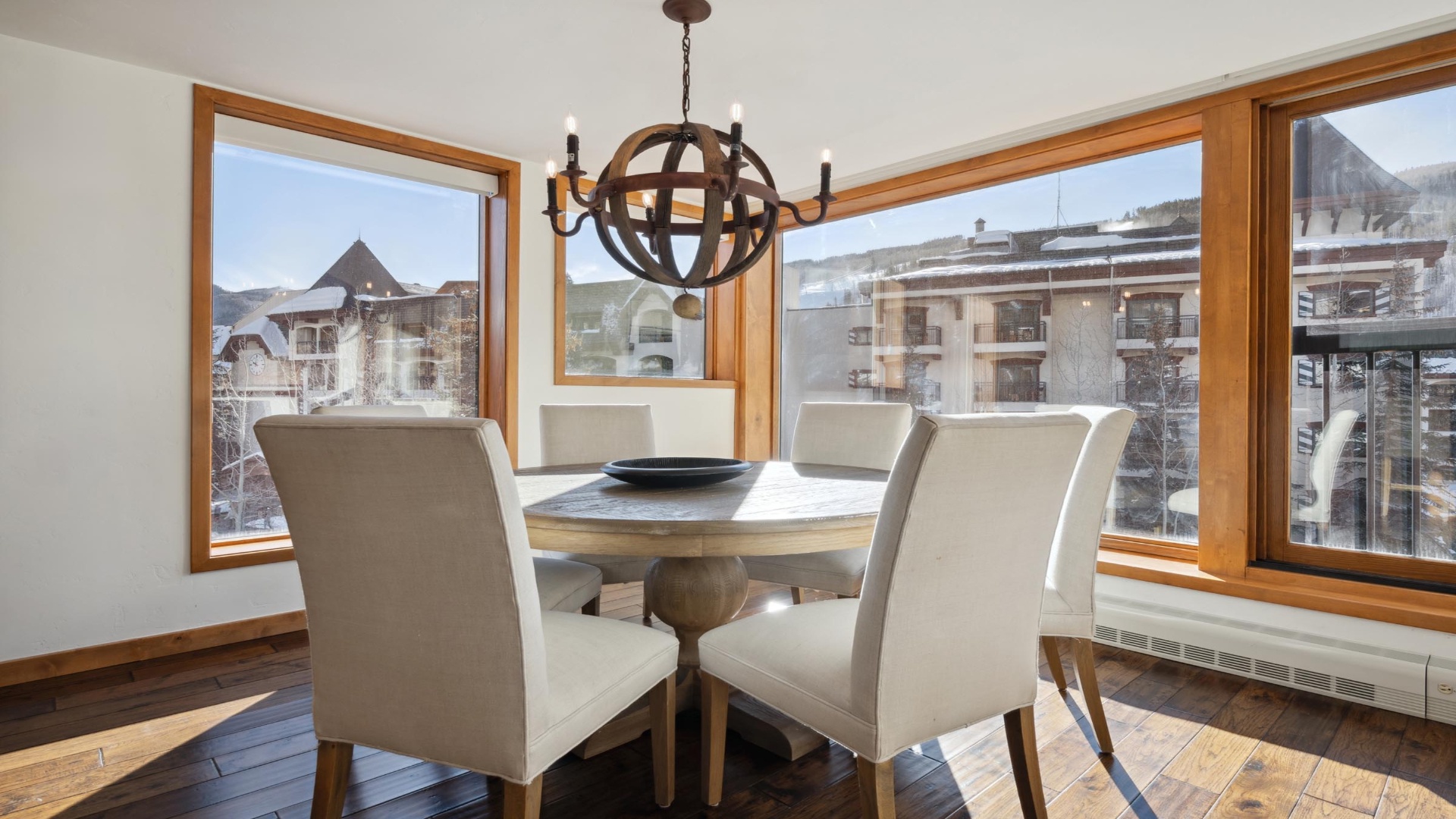 Enjoy your morning coffee at this elegant dining table, framed by mountain views that bring the alpine landscape right to your breakfast. The rustic chandelier and natural wood touches create warmth you'll feel instantly.