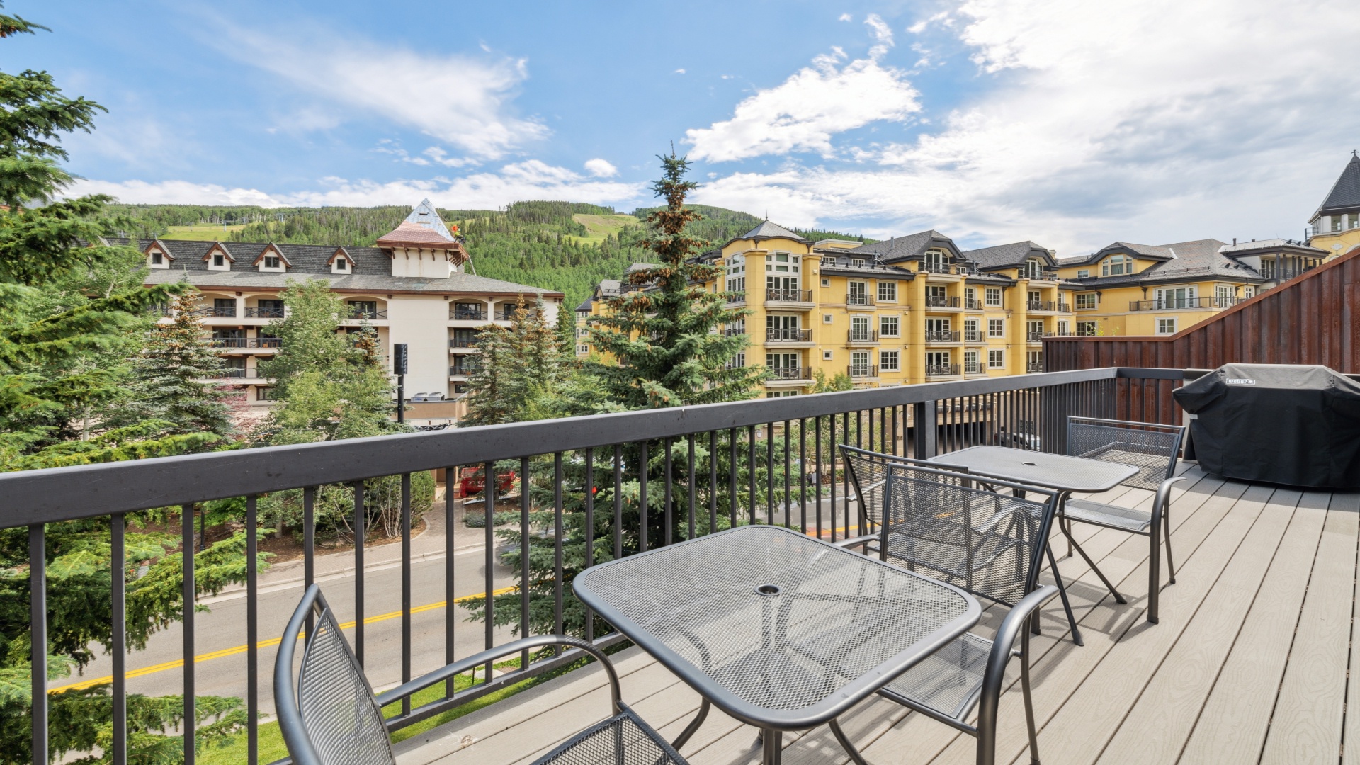 Enjoy your morning coffee on your private balcony, overlooking charming resort architecture and mountain views that stretch to the tree-lined slopes beyond.