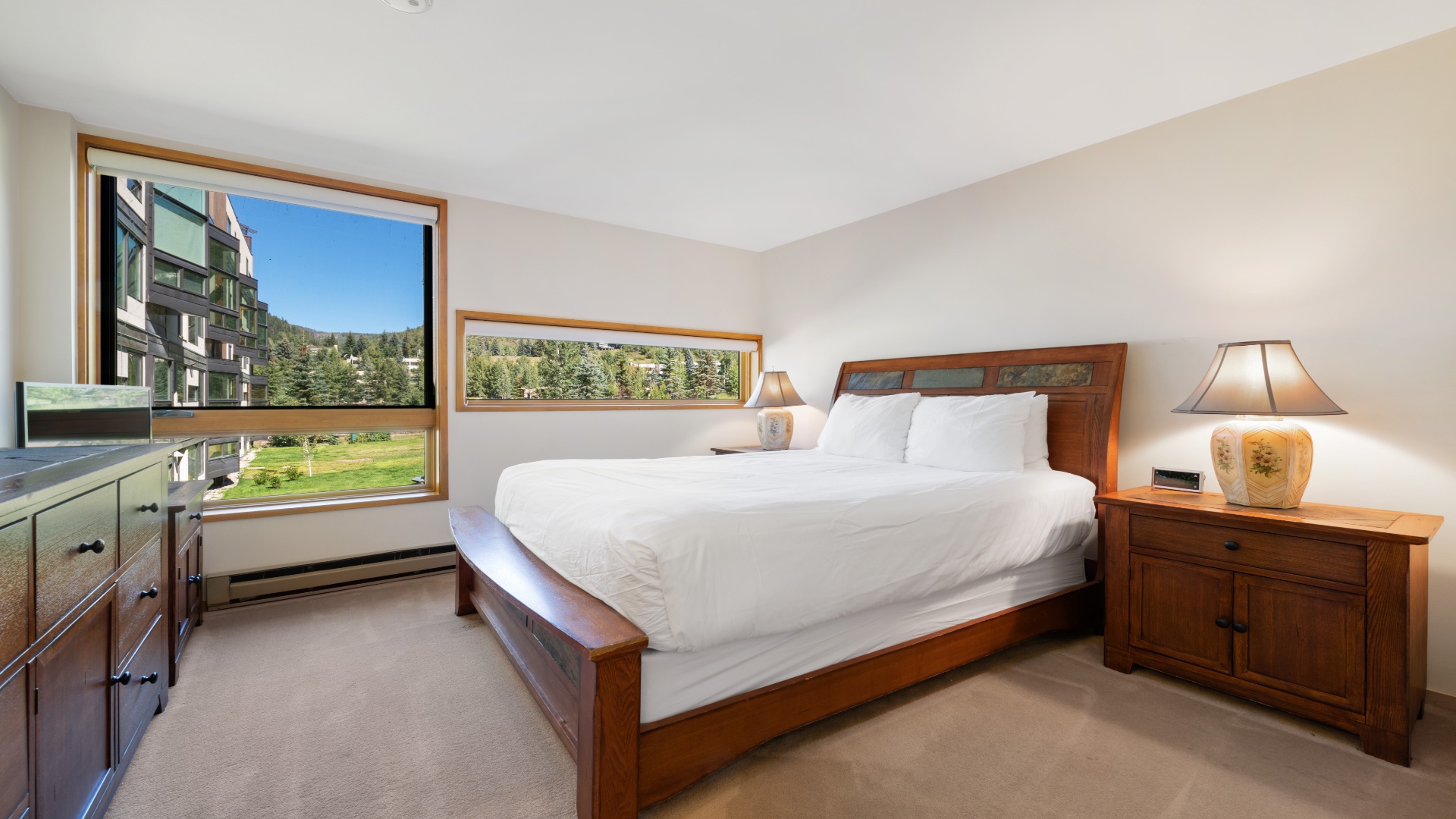 Wake up to stunning mountain and meadow views in your serene bedroom. Plush linens and warm wood furnishings create your perfect alpine retreat after a day of adventure.