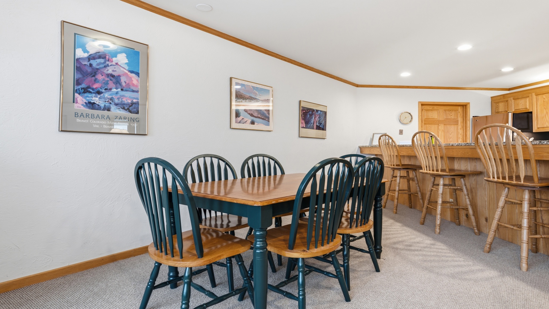 Gather around your spacious dining table with mountain artwork overhead, then head to the bar for conversation and laughter in this inviting, open space.