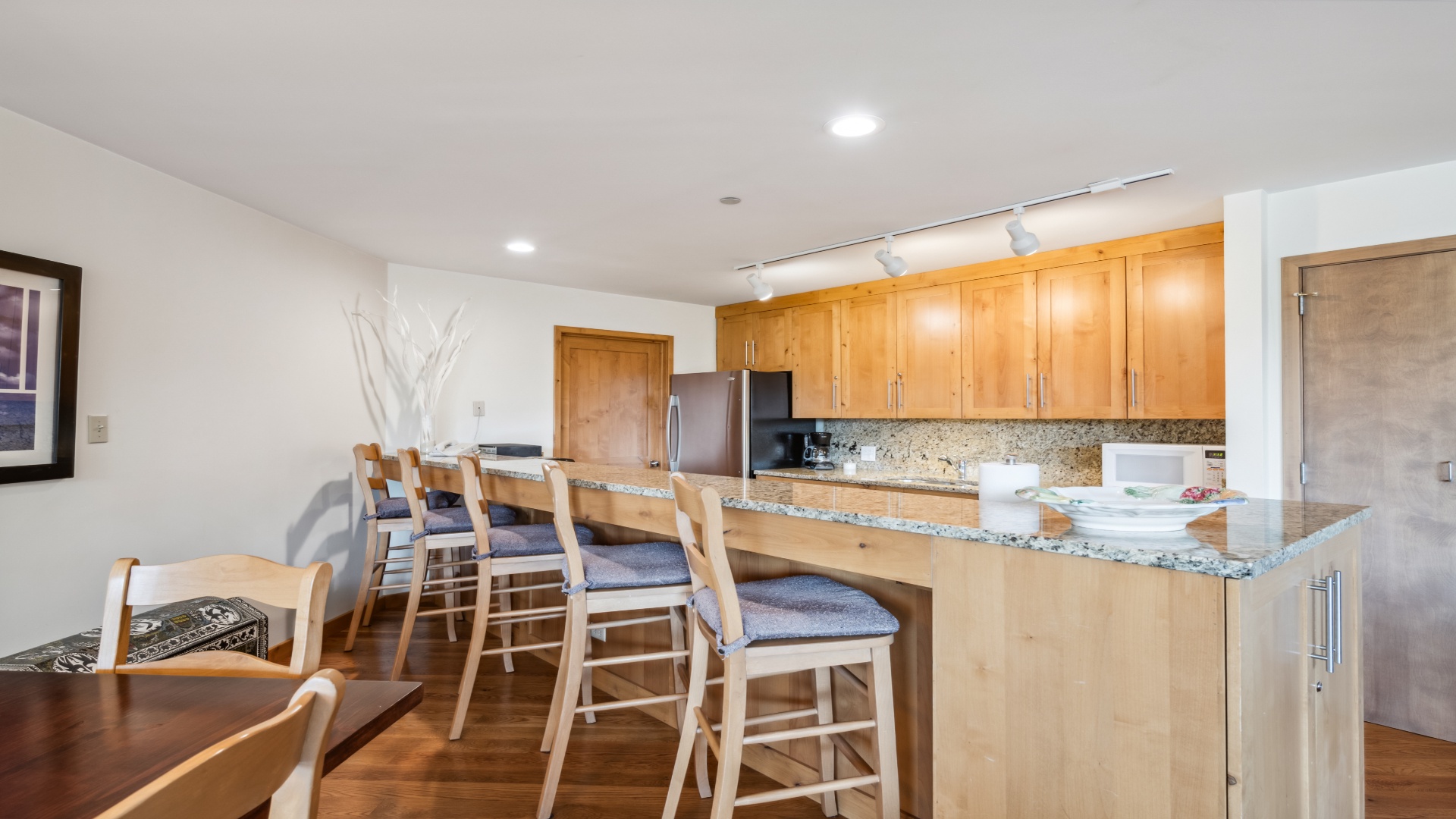 Your open kitchen and dining space invites relaxed meals with gleaming granite counters, warm wood cabinetry, and a breakfast bar perfect for morning coffee or evening gatherings.