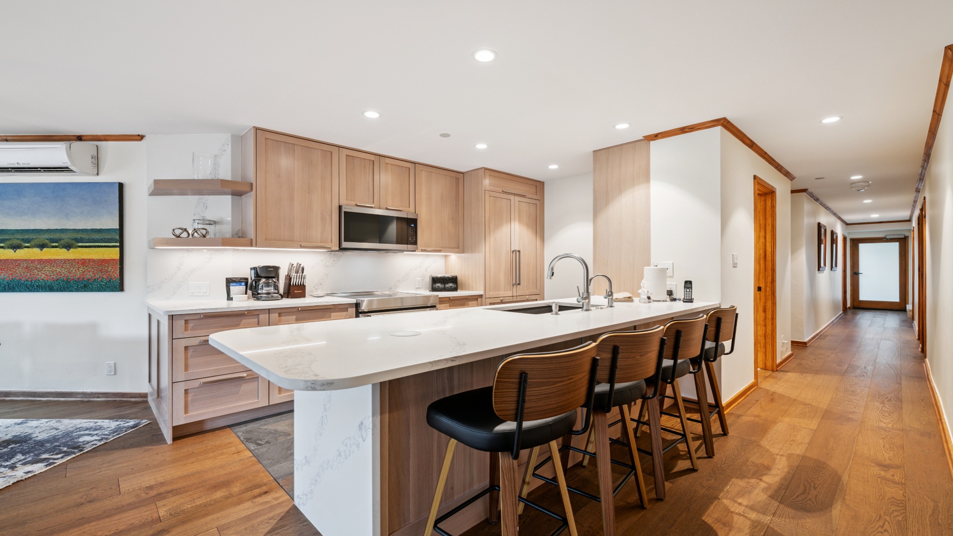 Your spacious kitchen awaits, featuring warm wood cabinetry, gleaming quartz countertops, and a large island perfect for gathering with family and friends over morning coffee or evening meals.