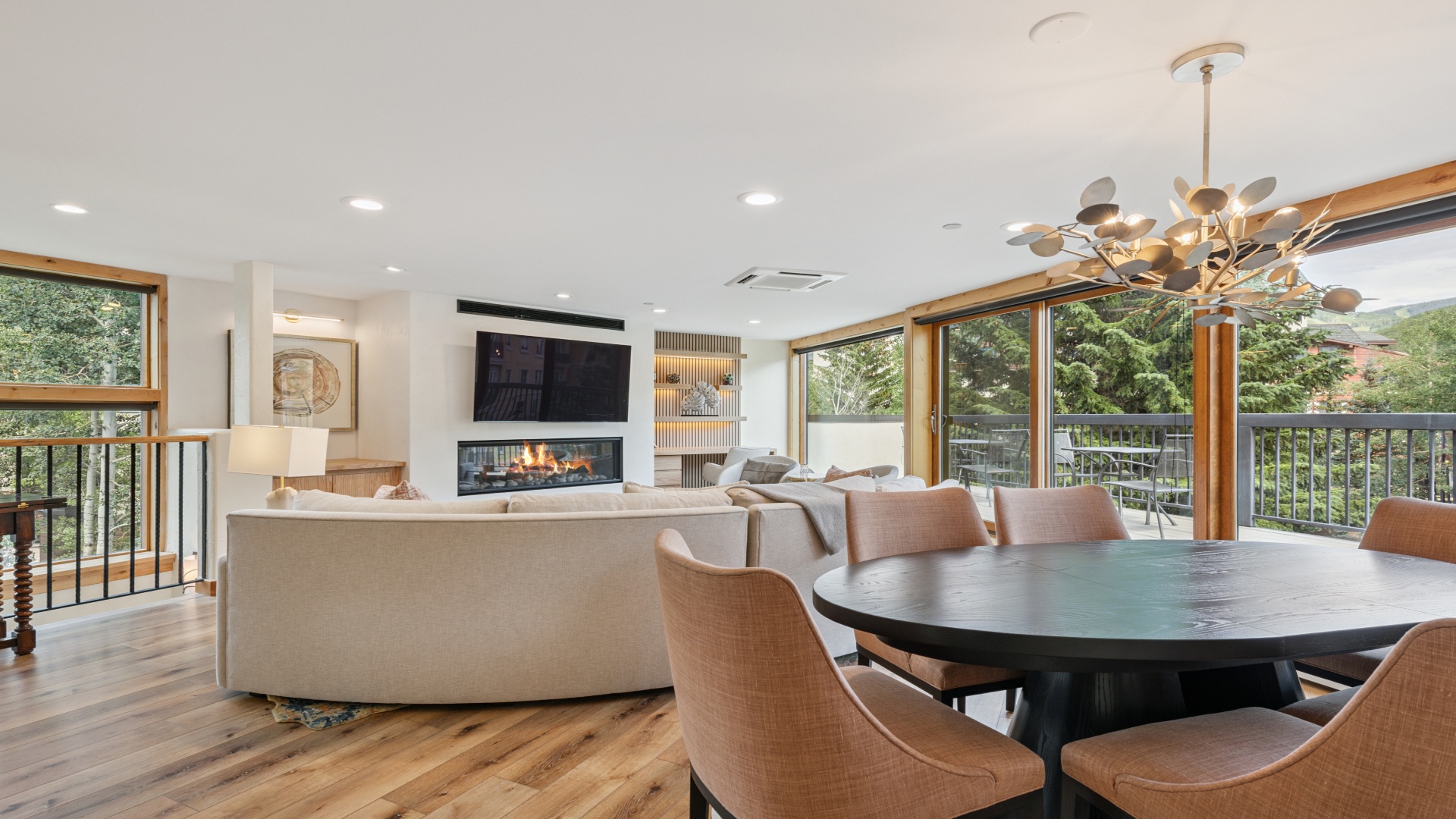 Unwind in your open-concept living space where natural light pours through floor-to-ceiling windows. Gather around the cozy fireplace or enjoy meals at your spacious dining table with treetop views.