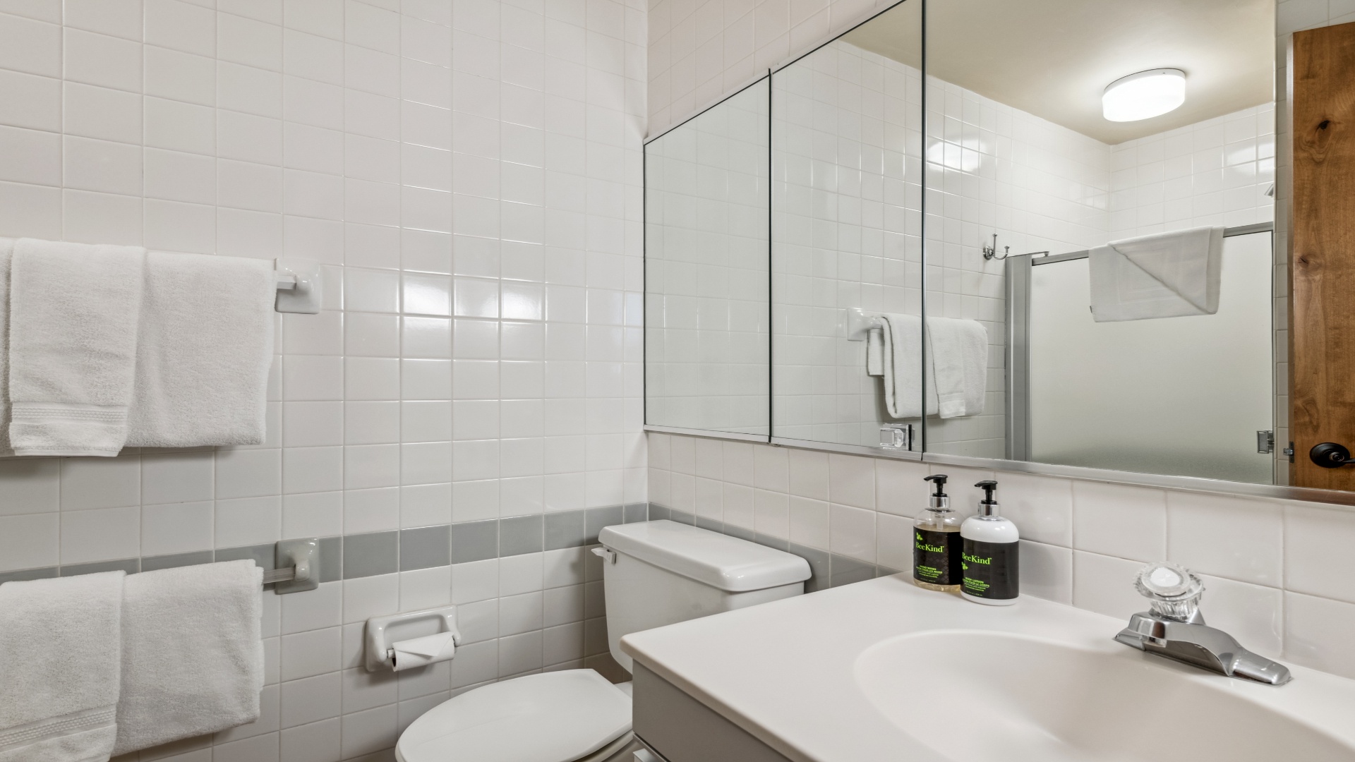 Your private bathroom features clean white subway tile, a spacious vanity, and plush towels awaiting your arrival. Everything you need for a refreshing stay is right here.