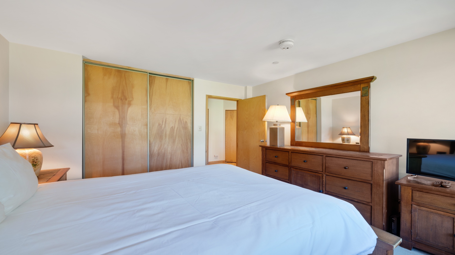 Sink into crisp linens and feel right at home in this inviting bedroom, where warm wood tones and soft lighting create your perfect retreat after a day of adventure.