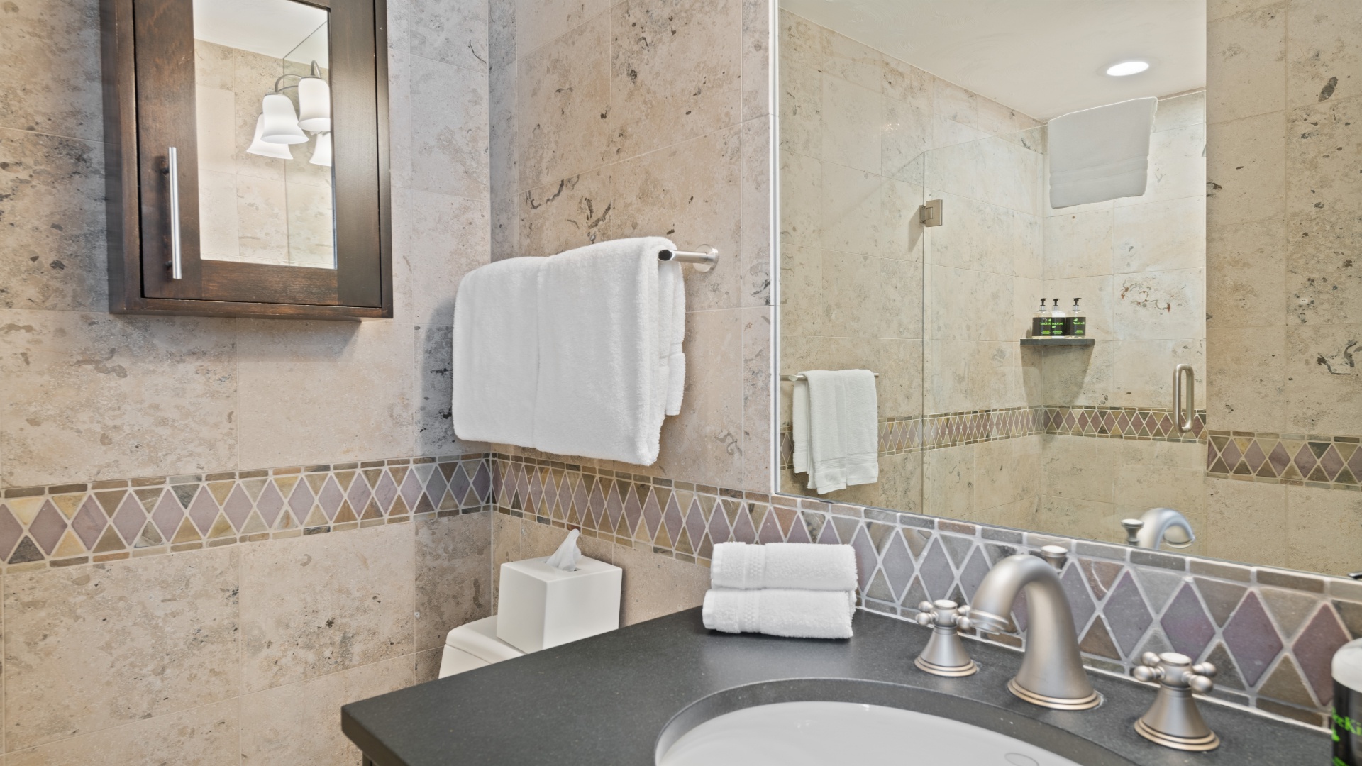 Refresh in your beautifully appointed bathroom featuring elegant tile work, plush towels, and a spacious walk-in shower designed for your comfort and relaxation.