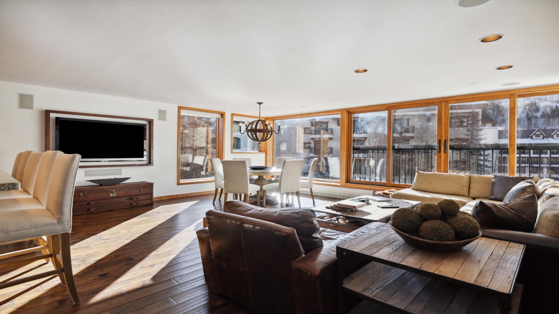 Settle into your spacious retreat with soaring ceilings, rich wood floors, and a wall of windows framing snowy mountain views—perfect for après-ski relaxation.