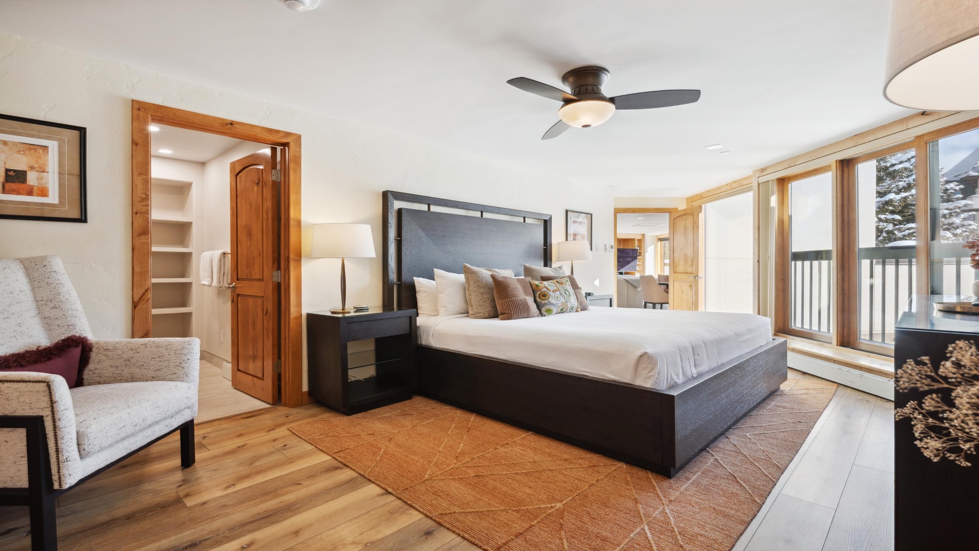 Your serene mountain retreat awaits in this spacious bedroom with hardwood floors, a plush king bed, and a private balcony overlooking snowy alpine views—perfect for waking up refreshed.