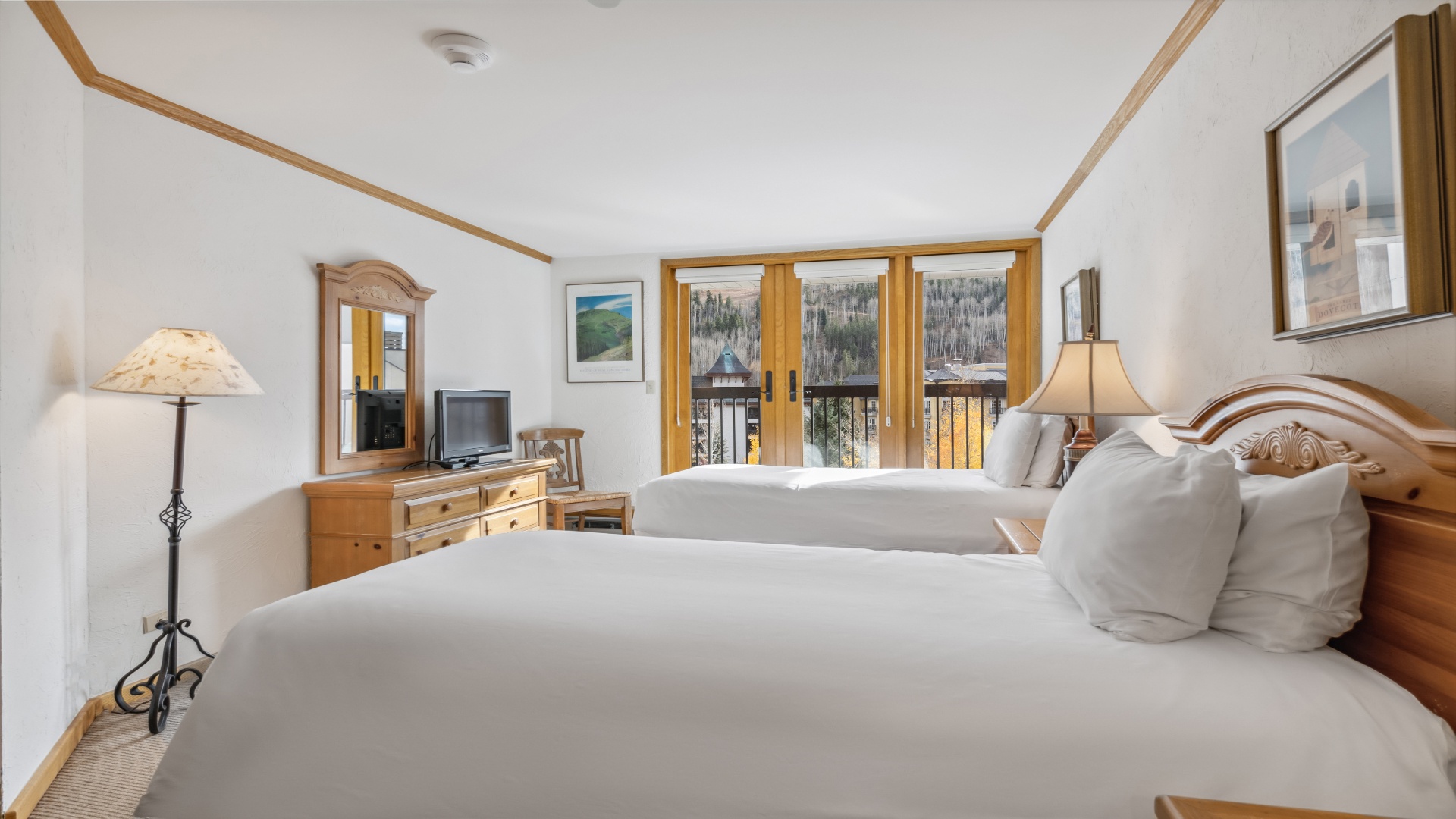 Sink into plush linens and wake to stunning mountain views framed by warm wood accents—your cozy alpine retreat awaits with all the comforts of home.