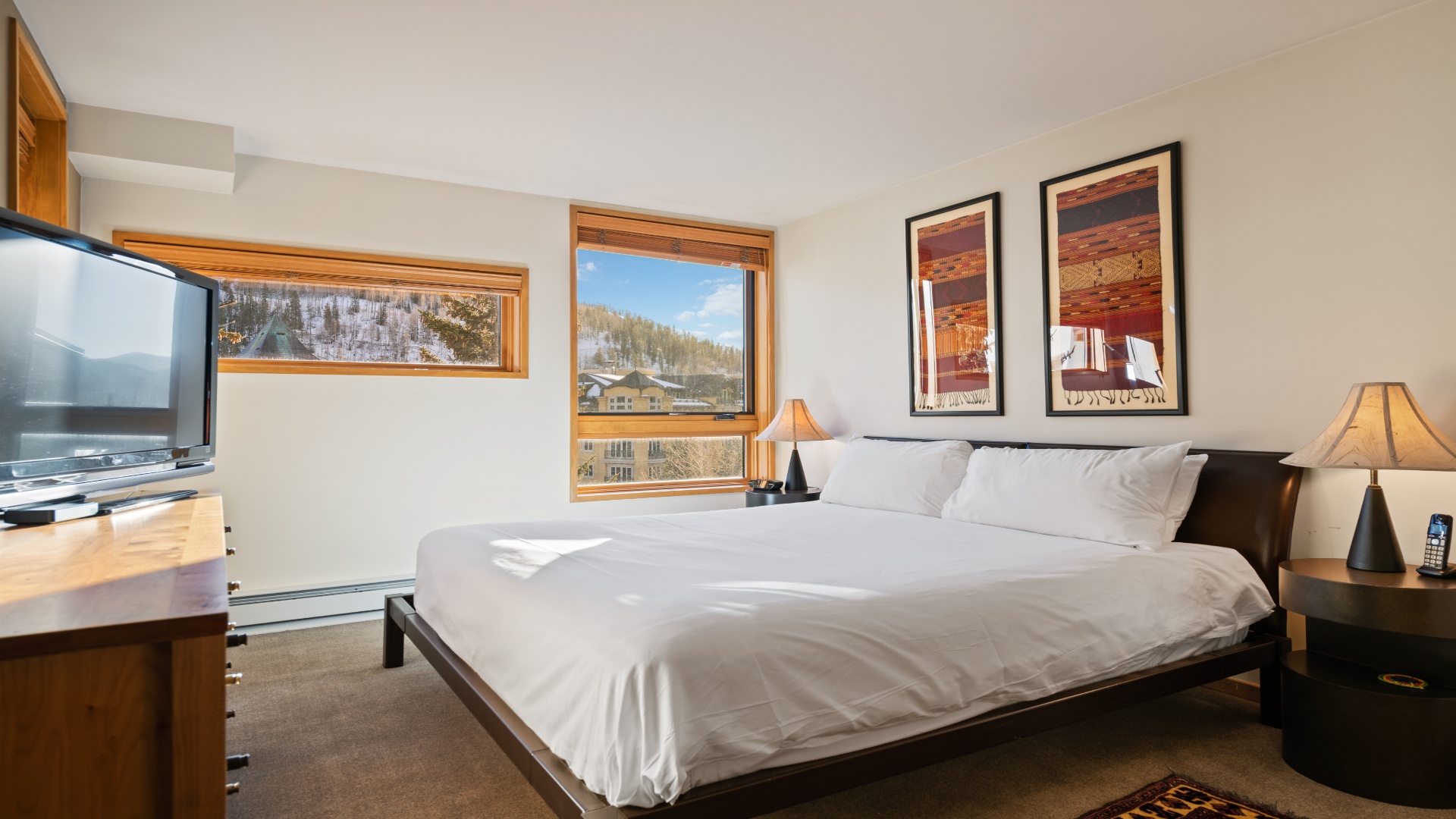 Sink into crisp linens and wake to mountain views framed by natural wood accents. Your peaceful retreat, complete with warm lighting and modern comforts.