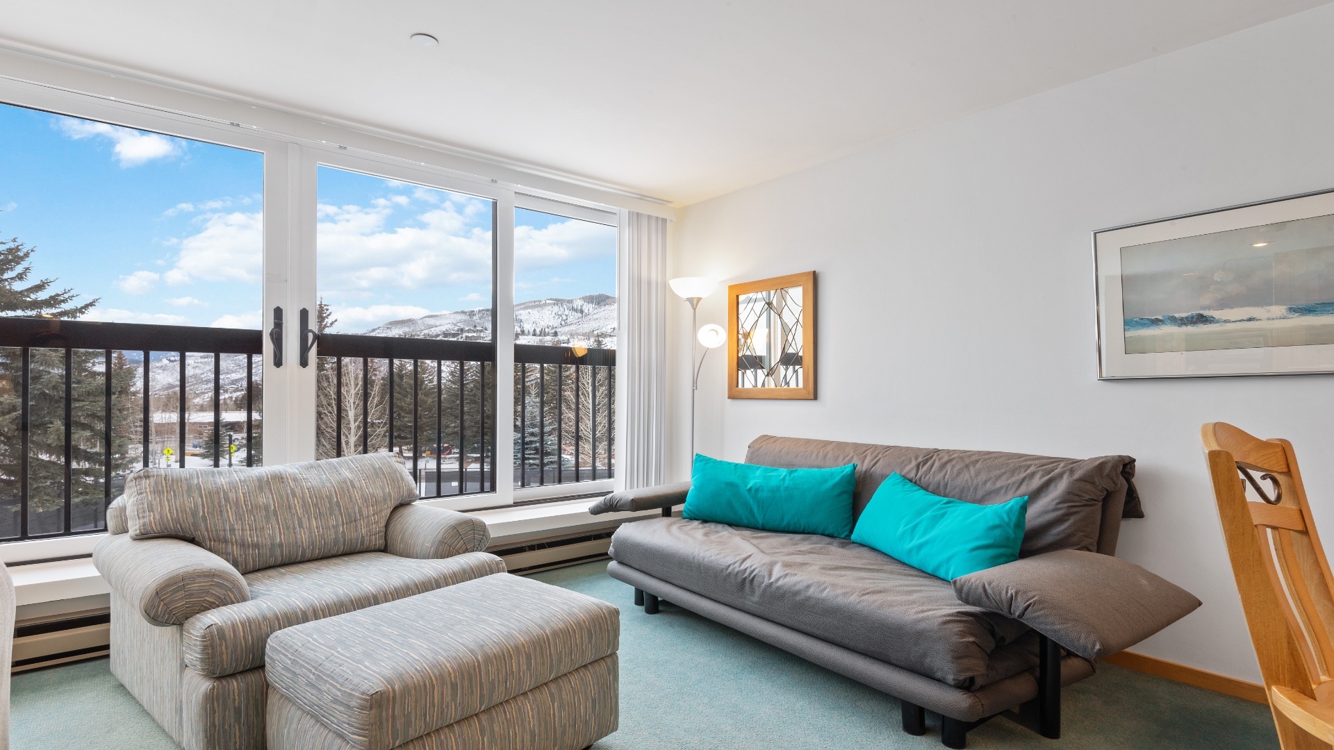 Relax on the comfortable sofas and enjoy stunning mountain views through expansive windows. Bright and inviting, this living area blends cozy seating with natural light and scenic surroundings perfect for unwinding.