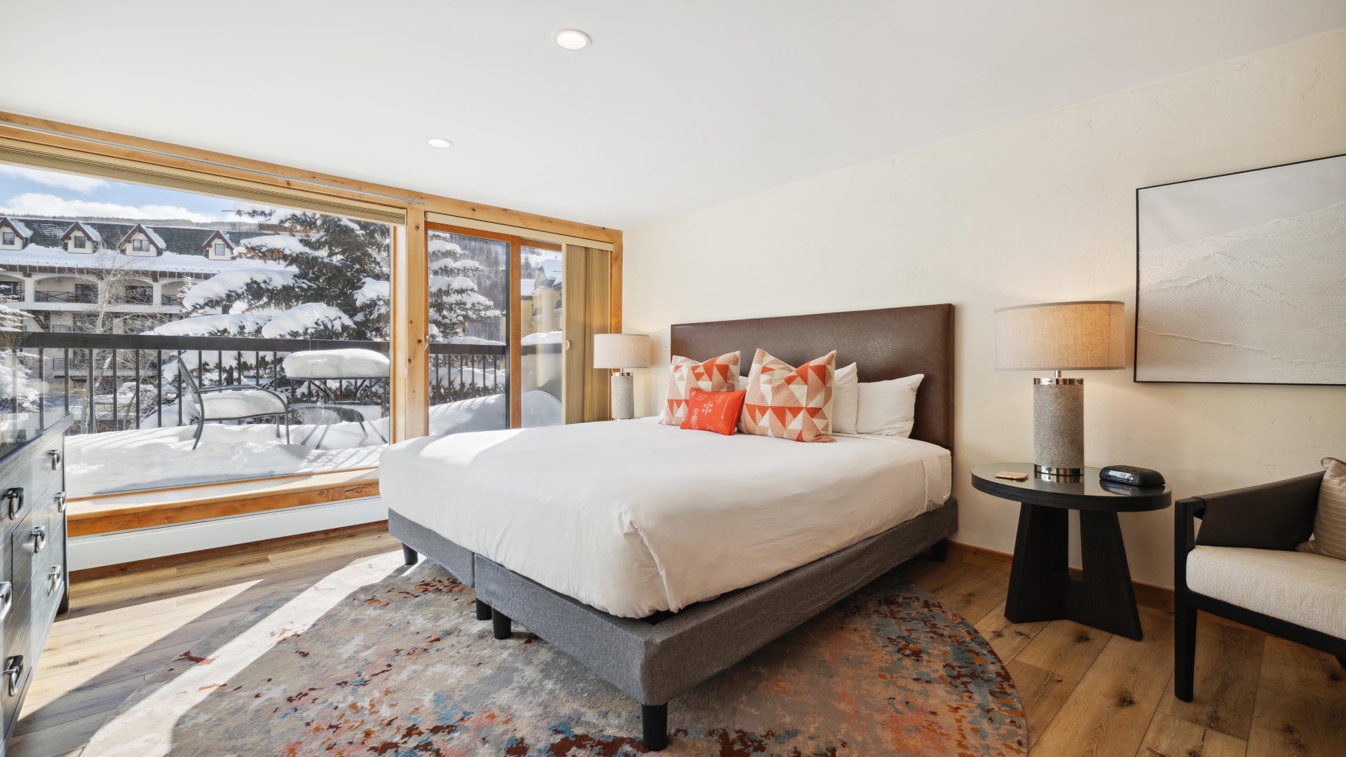 Sink into crisp white linens after a day on the slopes, with your private balcony framing a stunning winter mountain view just beyond your door.