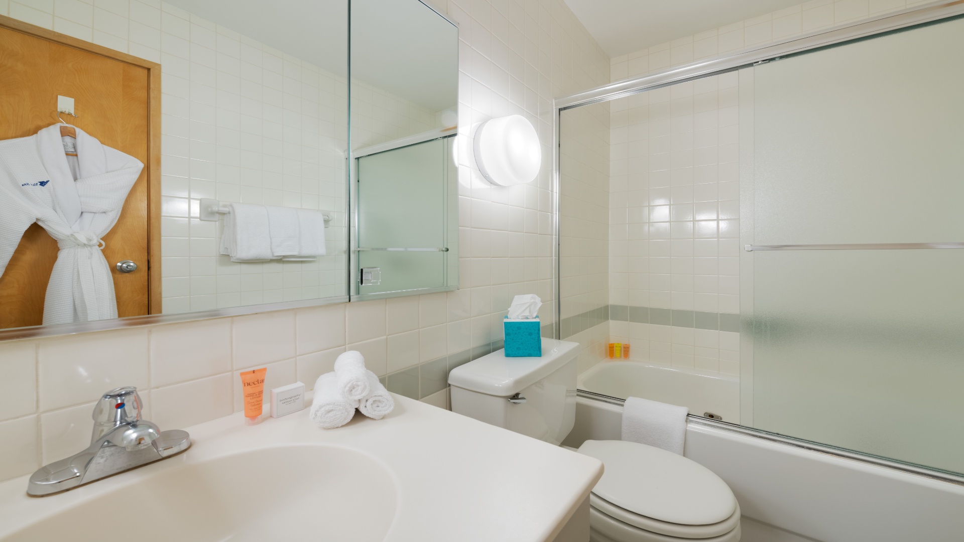 Step into your bright, sparkling bathroom, where crisp white towels and plush robes await. Enjoy your private tub-shower combo in this spotless, inviting space designed for your comfort and relaxation.