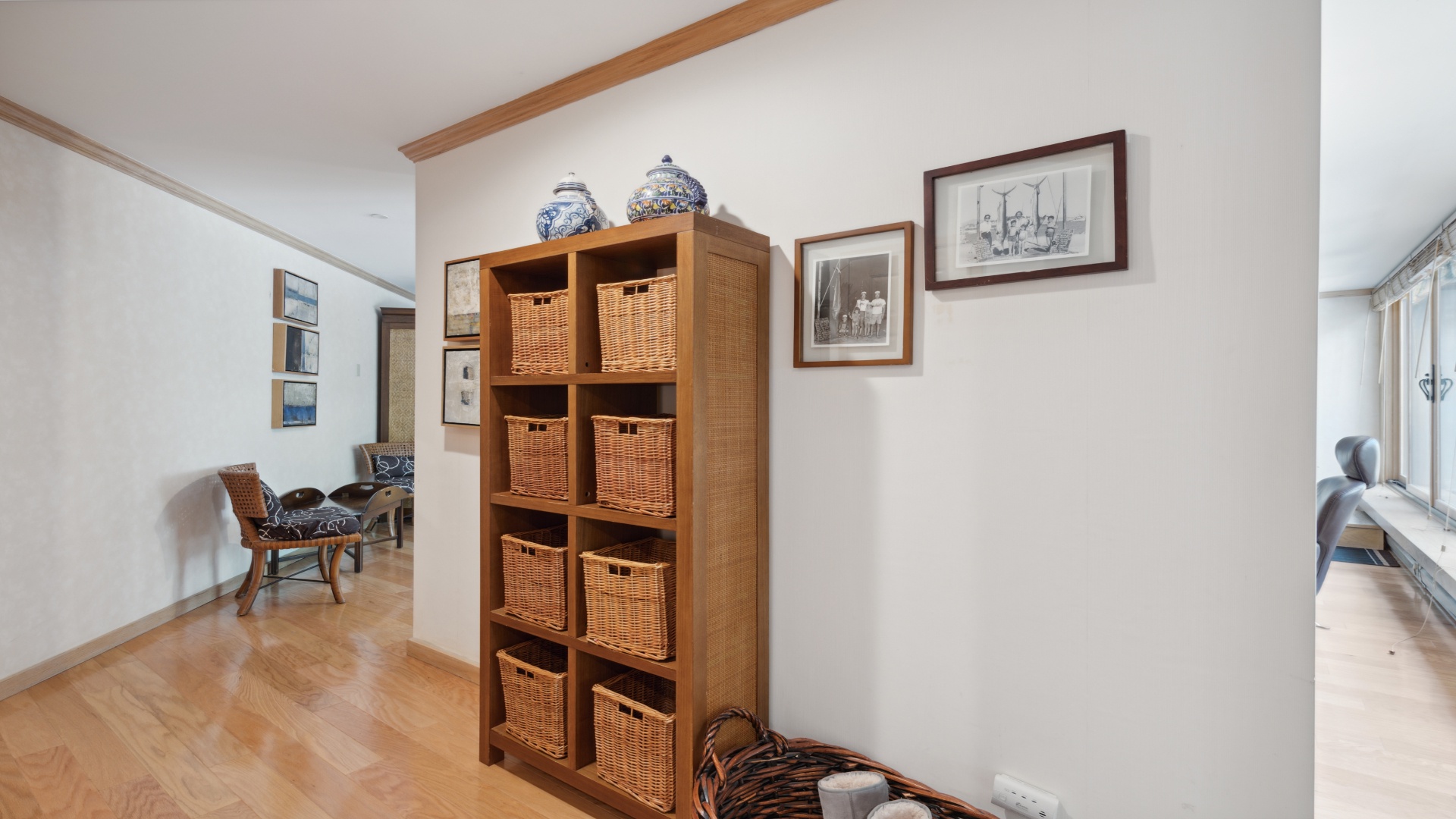 You'll love the thoughtful storage solutions here—wicker baskets in wooden cubbies keep your belongings organized, while warm hardwood floors and inviting decor create a calm, welcoming atmosphere.