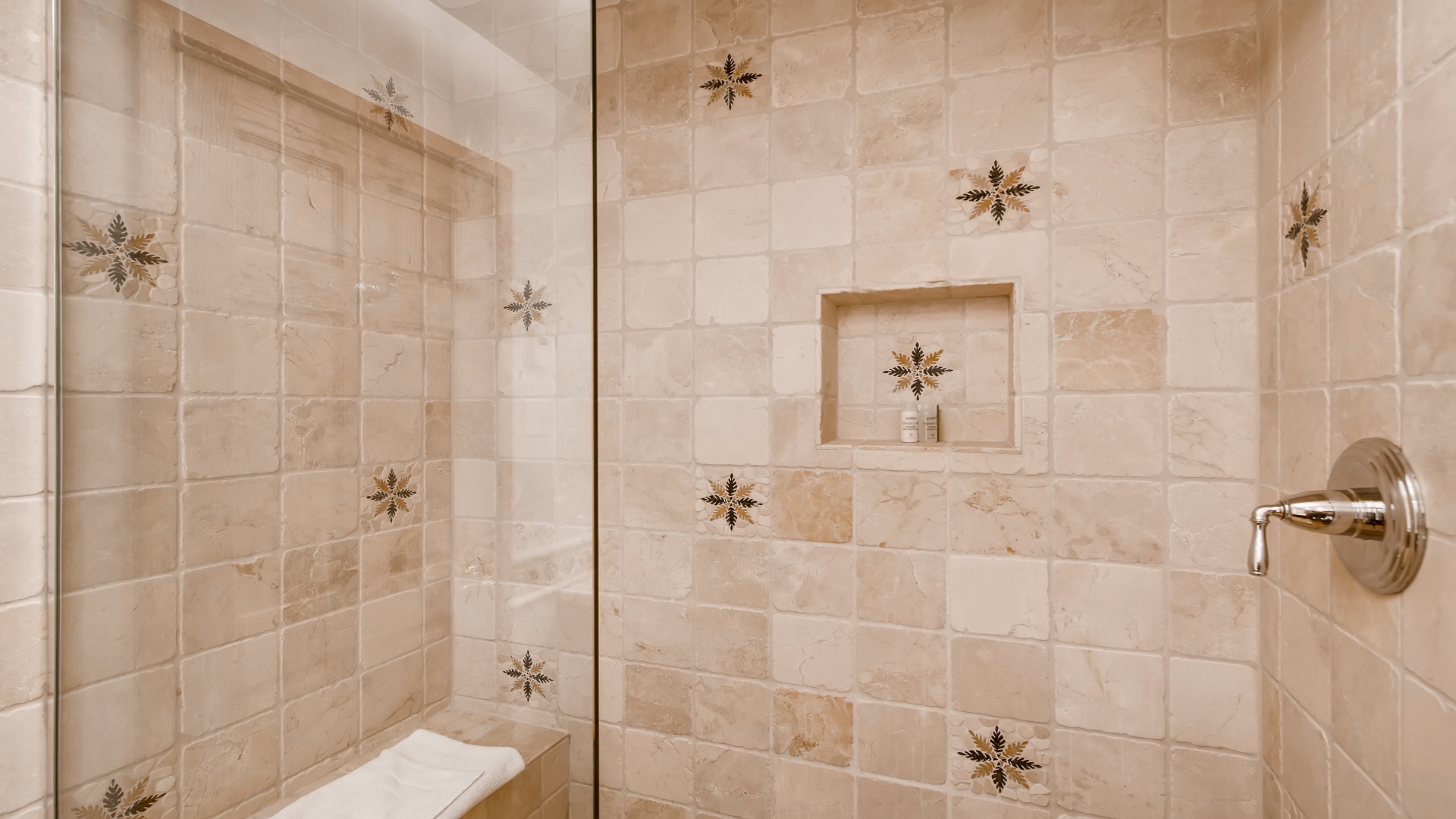 Beautifully tiled shower with elegant mosaic accents and a built-in niche for your essentials—your serene retreat after a day of adventure.