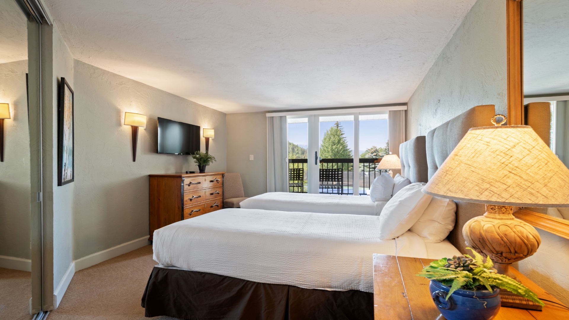 Sink into crisp linens and wake to natural light streaming through your balcony doors, framing serene outdoor views just beyond your private retreat.