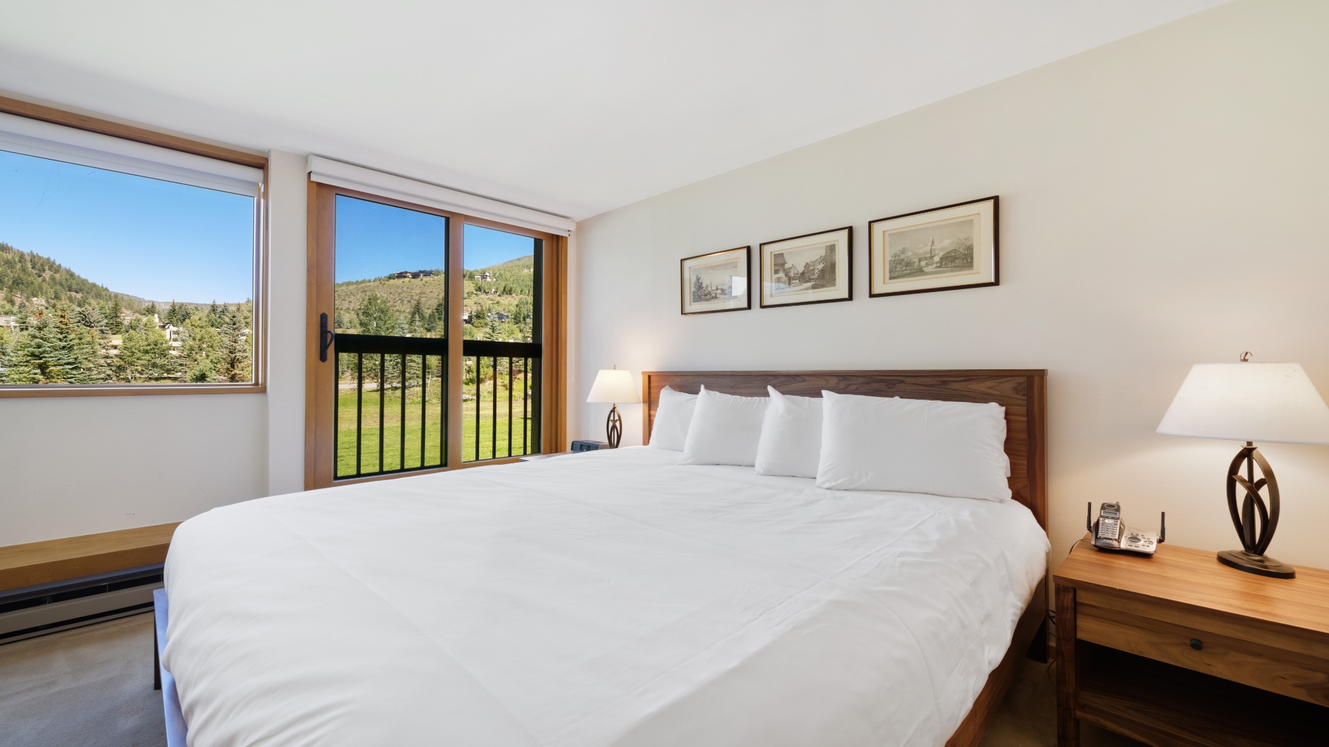 Your restful retreat features crisp linens and stunning mountain views framed by large windows. Wake up to green slopes and forest scenes, with thoughtful touches throughout for your comfort.