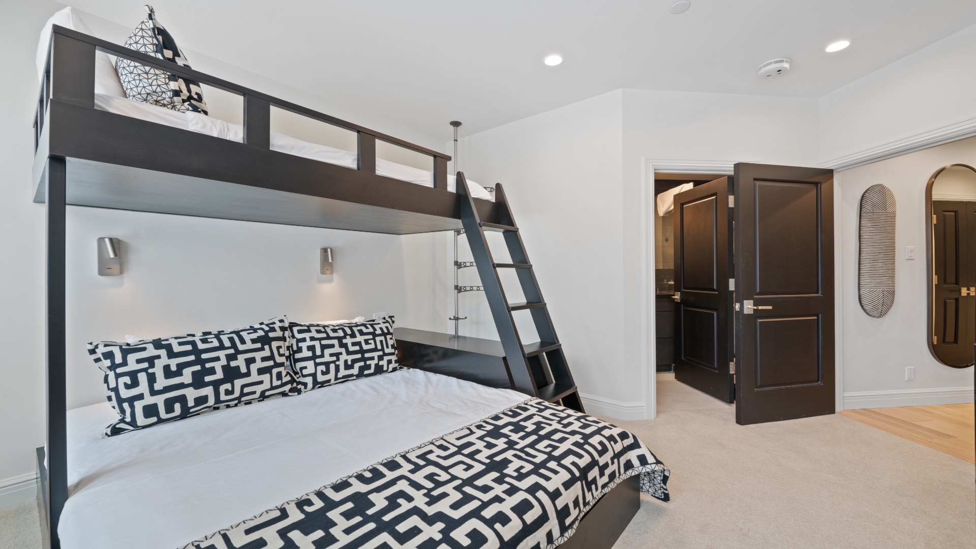 Rest easy in this stylish bunk room where bold geometric bedding and sleek modern fixtures create your perfect retreat. The space-saving design and cozy reading lights ensure everyone enjoys a comfortable night's sleep.