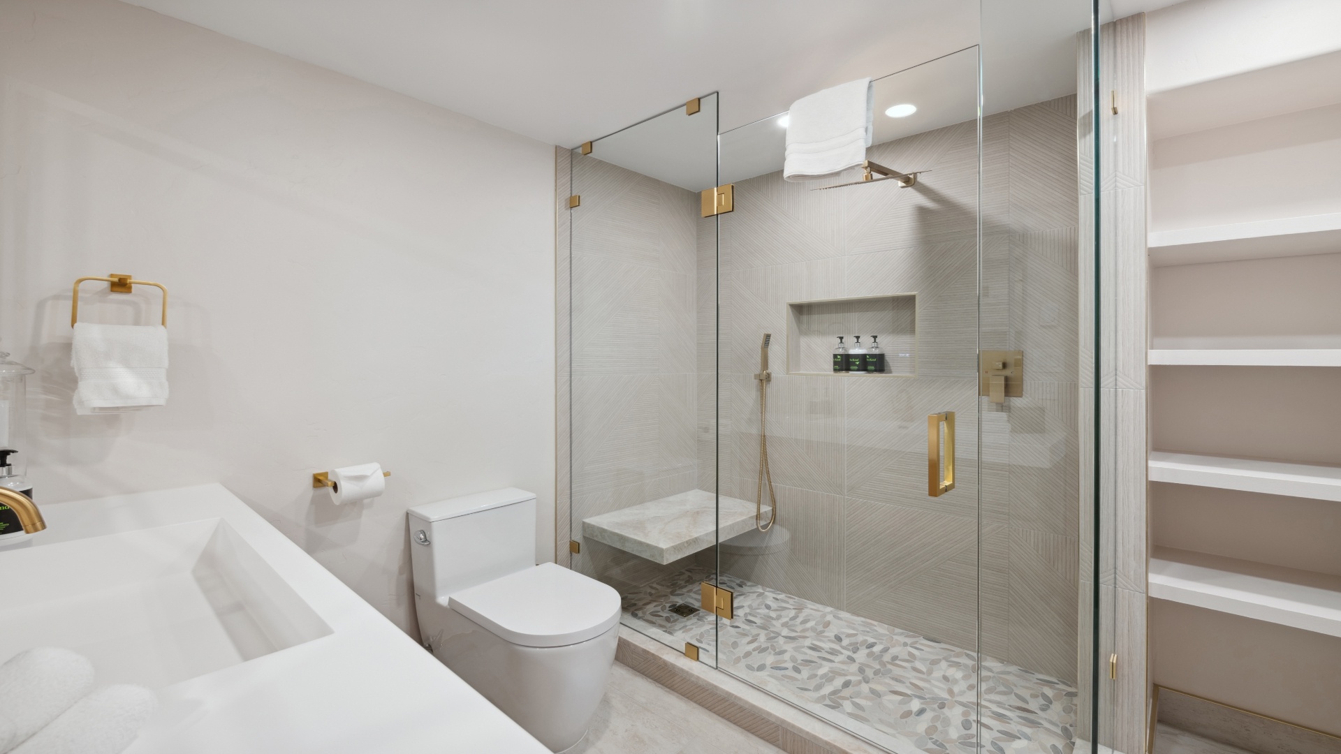 Indulge in your private spa-like bathroom with elegant gold fixtures, a spacious walk-in shower, and thoughtful details that make your stay feel luxurious.