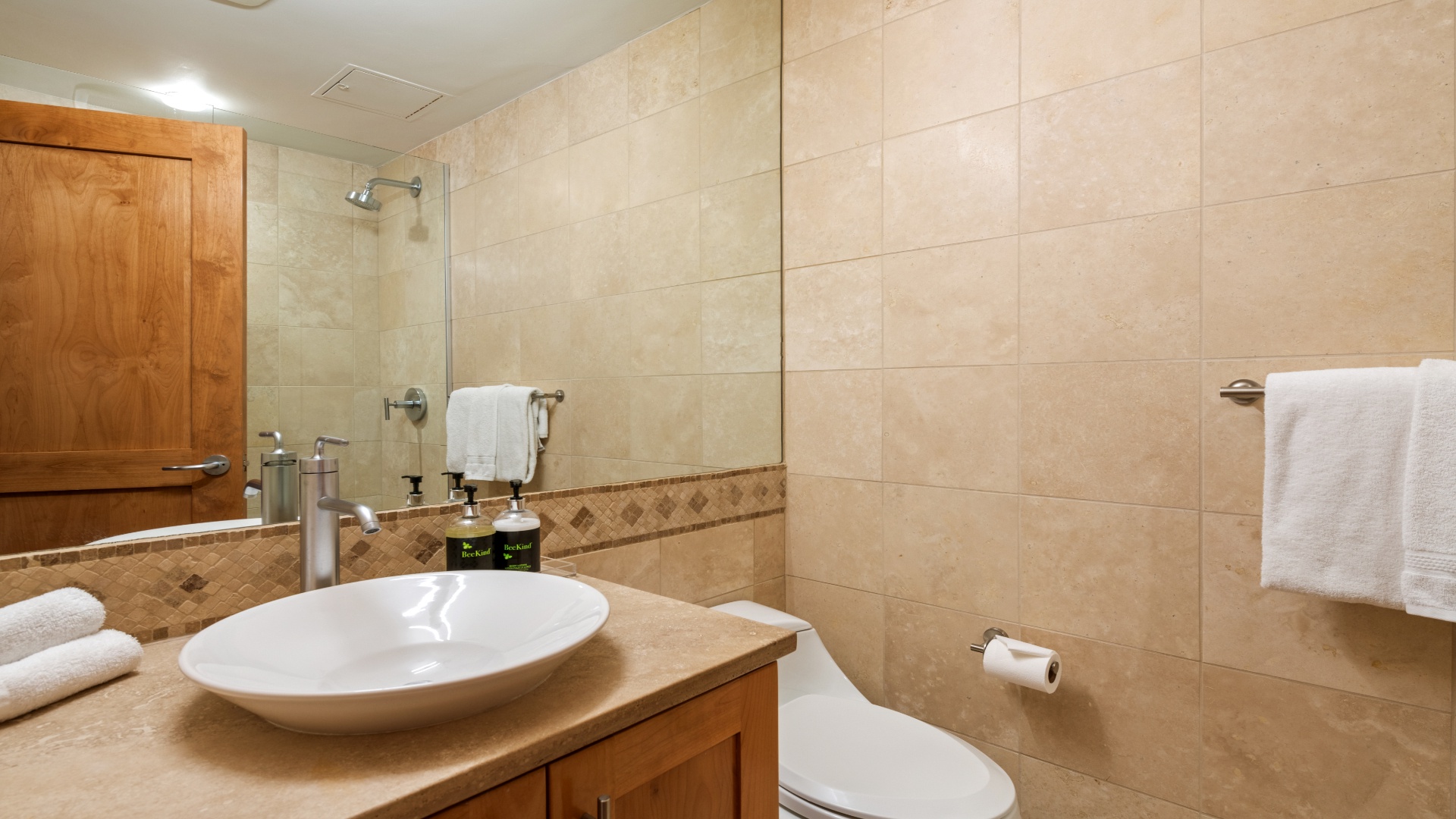 Step into your private bathroom with warm travertine tiling, a walk-in shower, vessel sink, and plush towels—everything you need to unwind after a day of adventure.