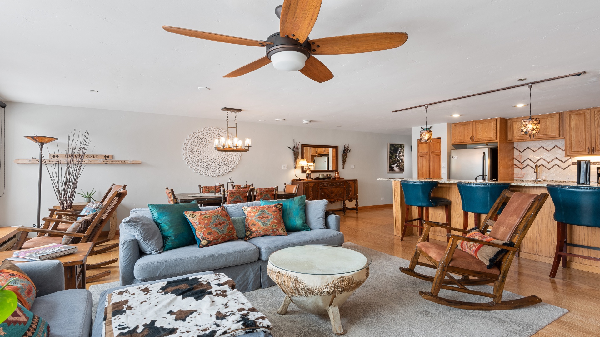 Relax into this beautifully designed open-concept space, where warm wood accents, a ceiling fan, and inviting seating create your perfect retreat.
