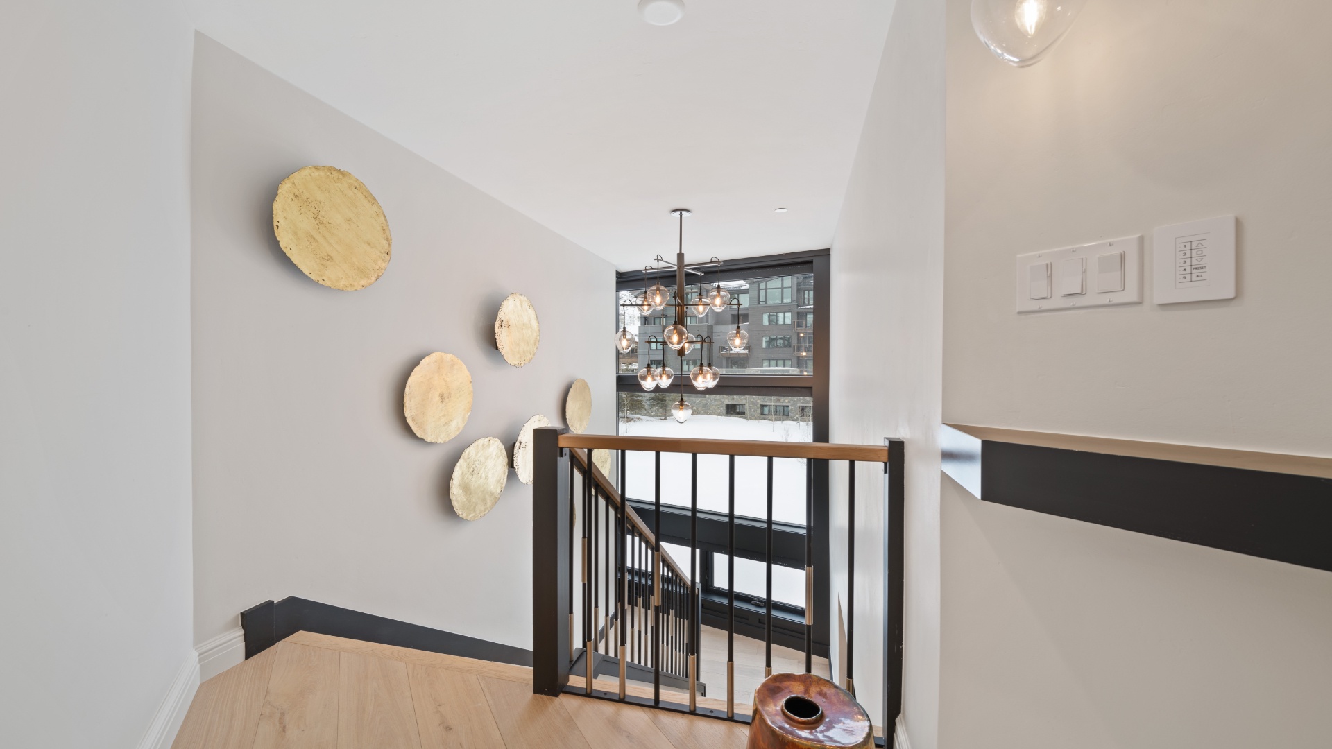 Your stairwell blends natural textures with modern elegance. Warm wood steps, artistic wall accents, and sleek fixtures create an inviting transition between floors in your stylish retreat.