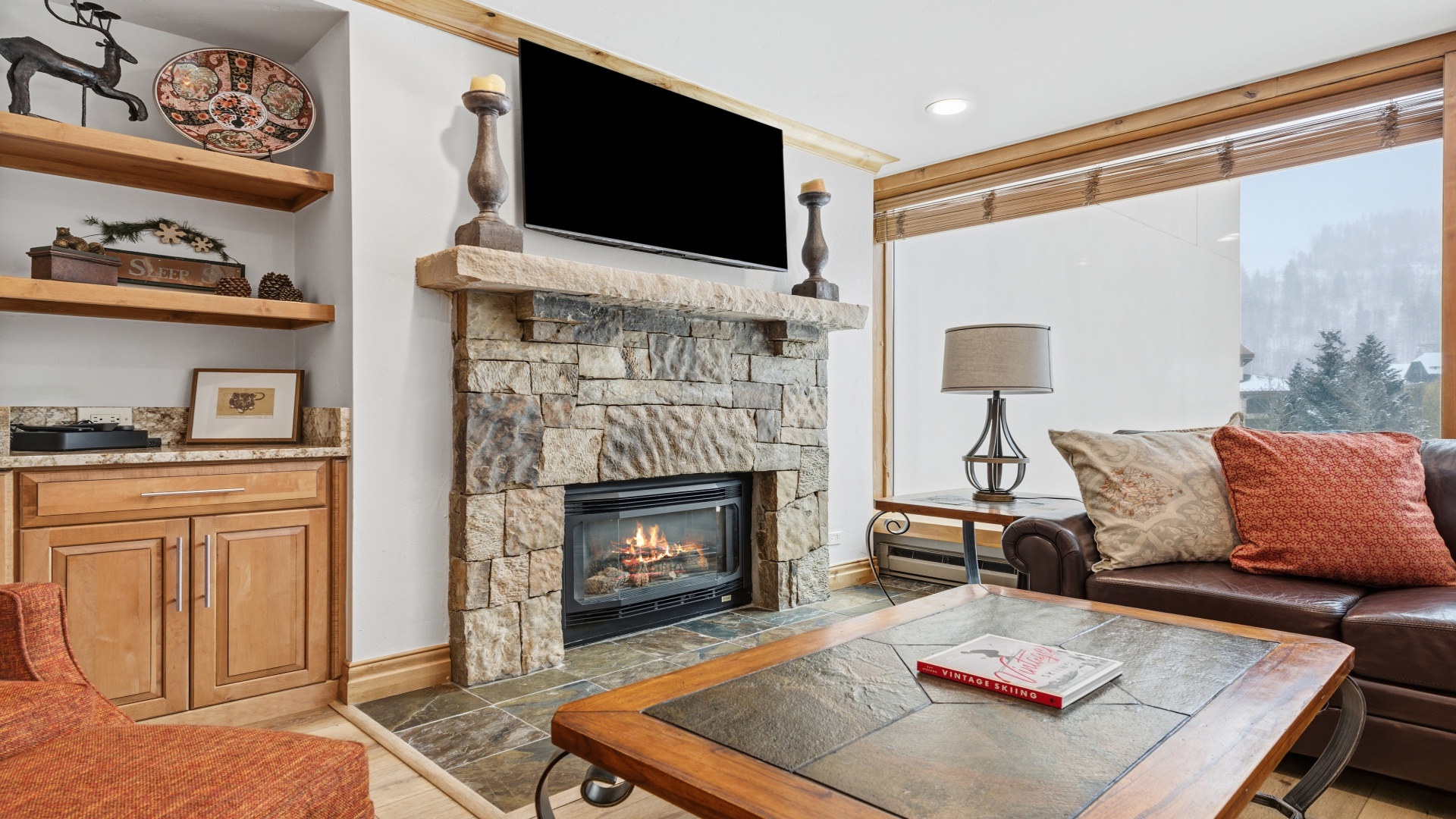 Sink into the leather sofa by your stone fireplace, where mountain views meet cozy warmth. Your perfect retreat for relaxing after a day of adventure.