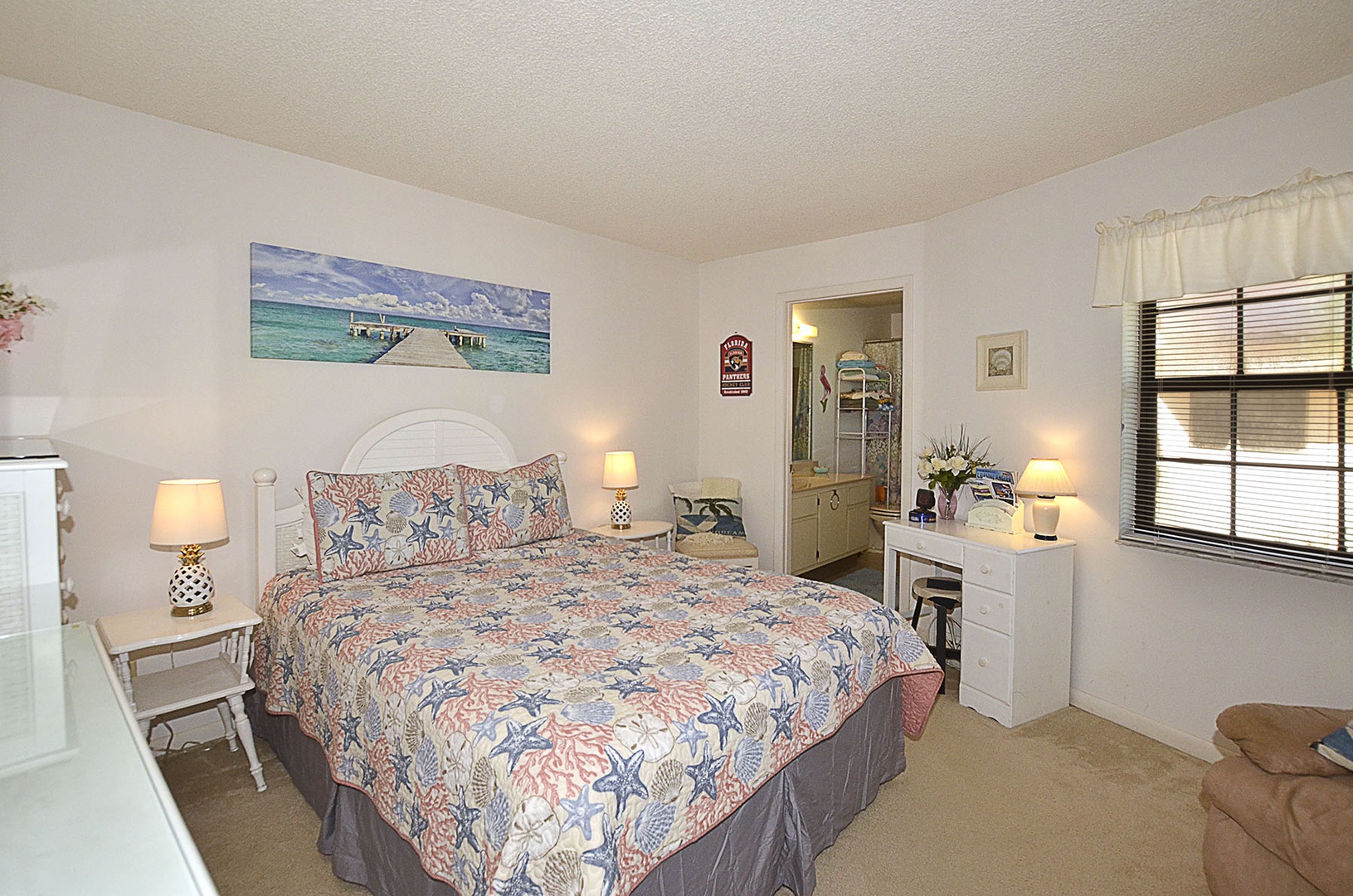 Drift off to sleep in your cozy coastal bedroom, where ocean-themed artwork and warm lighting create the perfect beach getaway retreat.