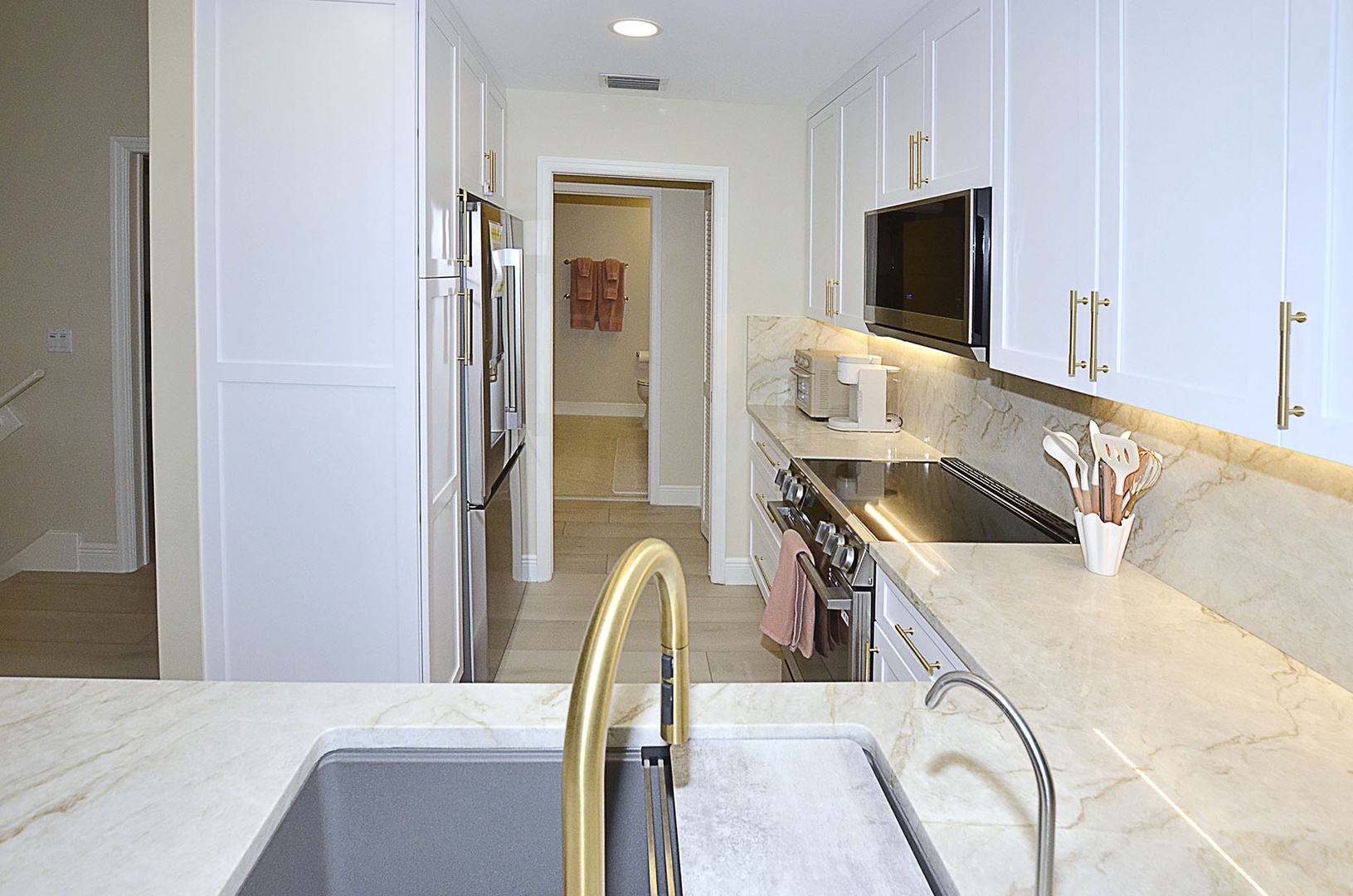 Kitchen. Your modern kitchen awaits with gleaming marble countertops, premium appliances, and crisp white cabinetry for effortless vacation cooking.