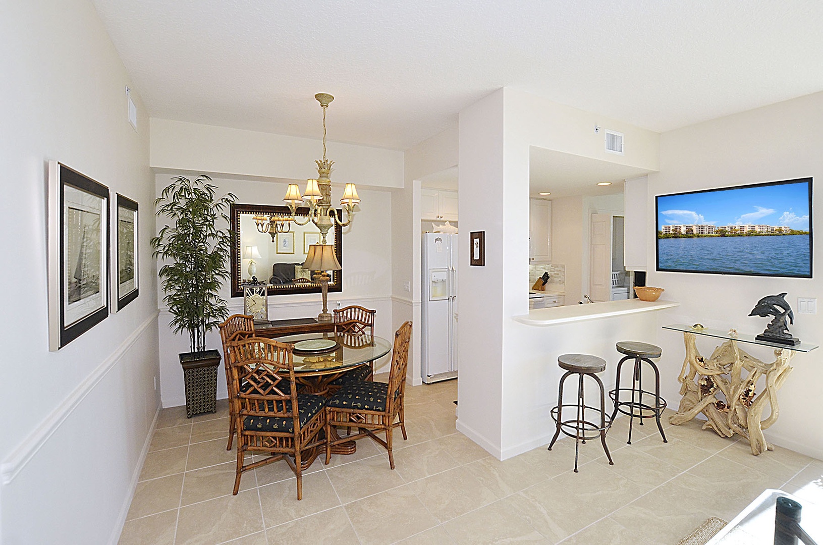 Your open-concept dining and entertainment area features coastal charm with bamboo furnishings and a large TV for memorable evenings together.