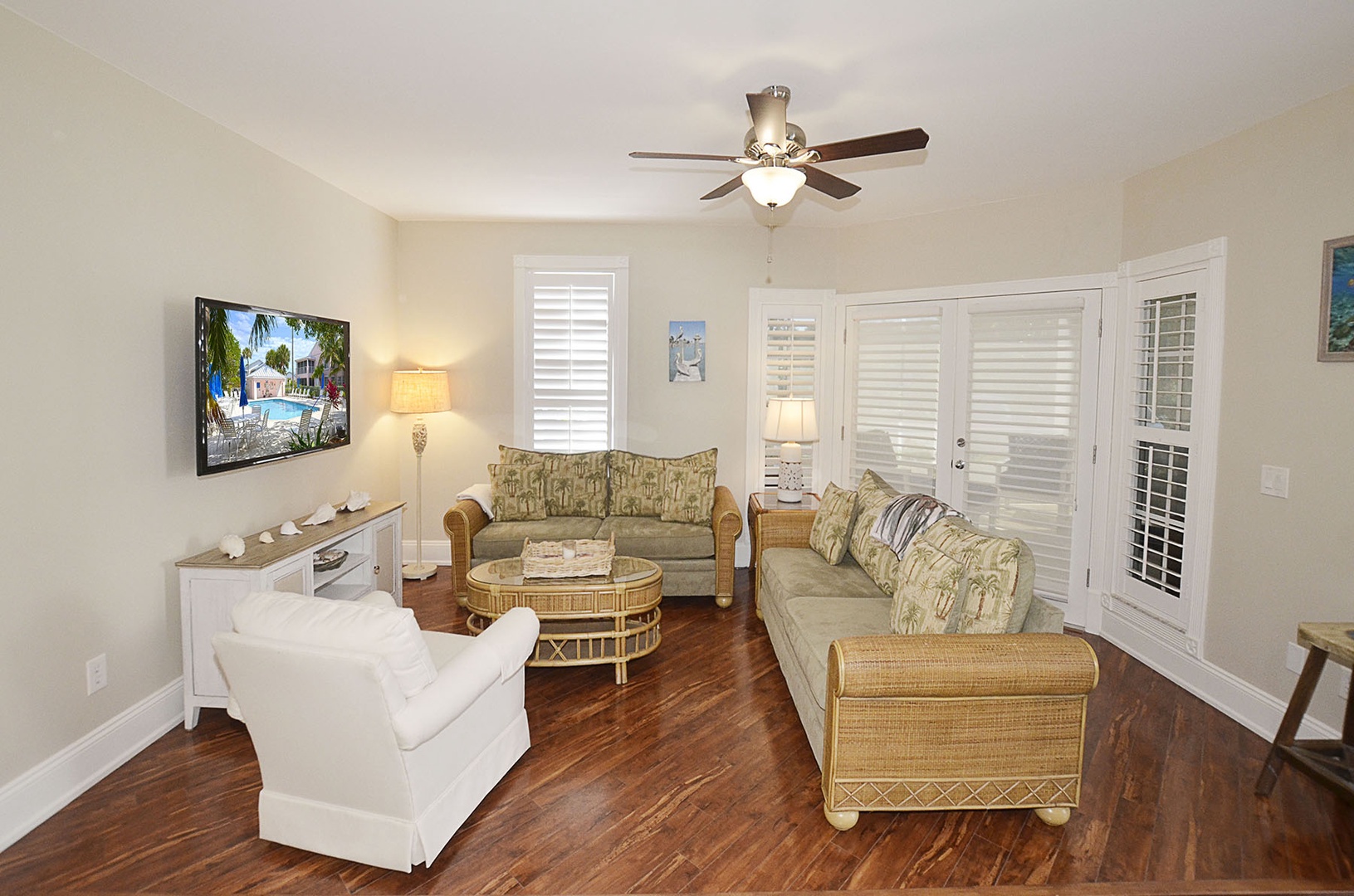 Your comfortable living room awaits with tropical touches, plush seating, and a ceiling fan to keep you cool during relaxing evenings.