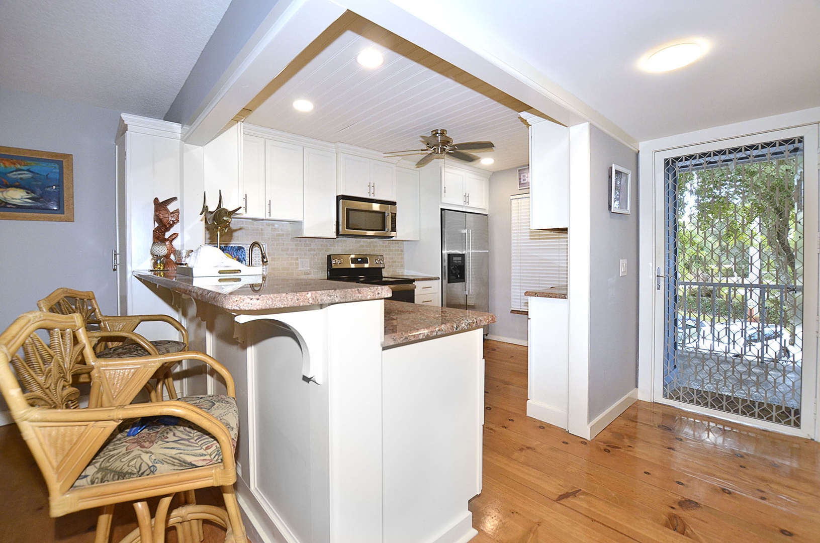 Kitchen. Your fully equipped kitchen invites culinary adventures with granite countertops, stainless appliances, and tropical-style seating.