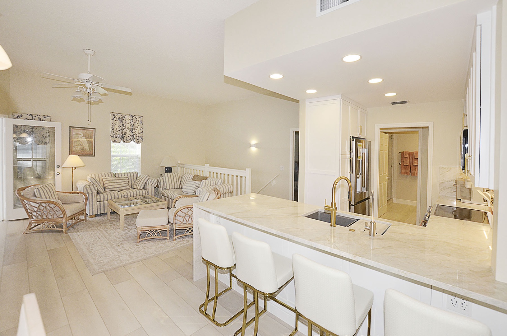 Kitchen / Living. You'll love this bright, open-concept space where elegant white kitchen flows into cozy living area with striped seating perfect for relaxing.