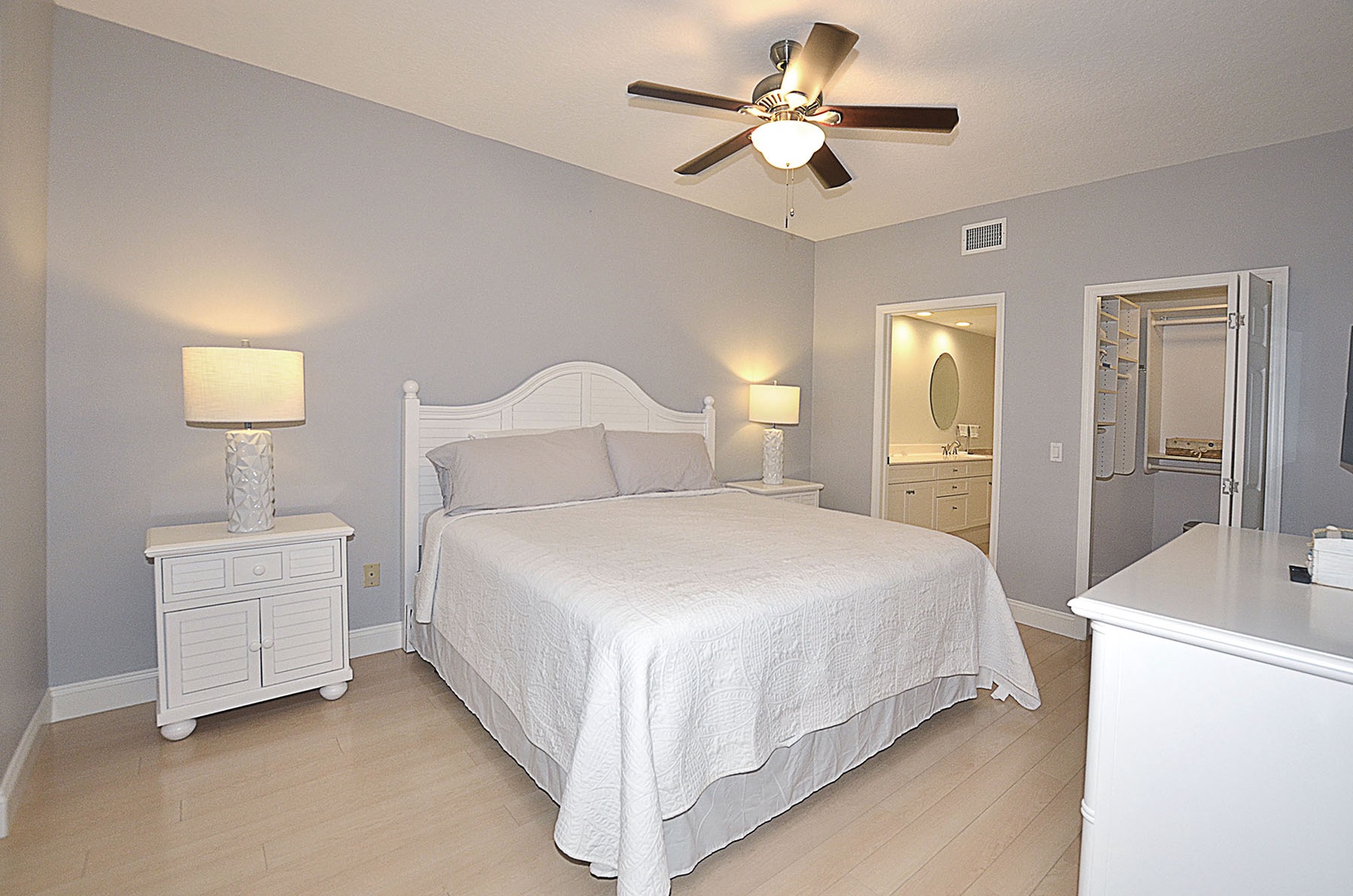 The Main bedroom retreat features soft lighting, coastal-inspired furnishings, and an ensuite bathroom for ultimate comfort and privacy.