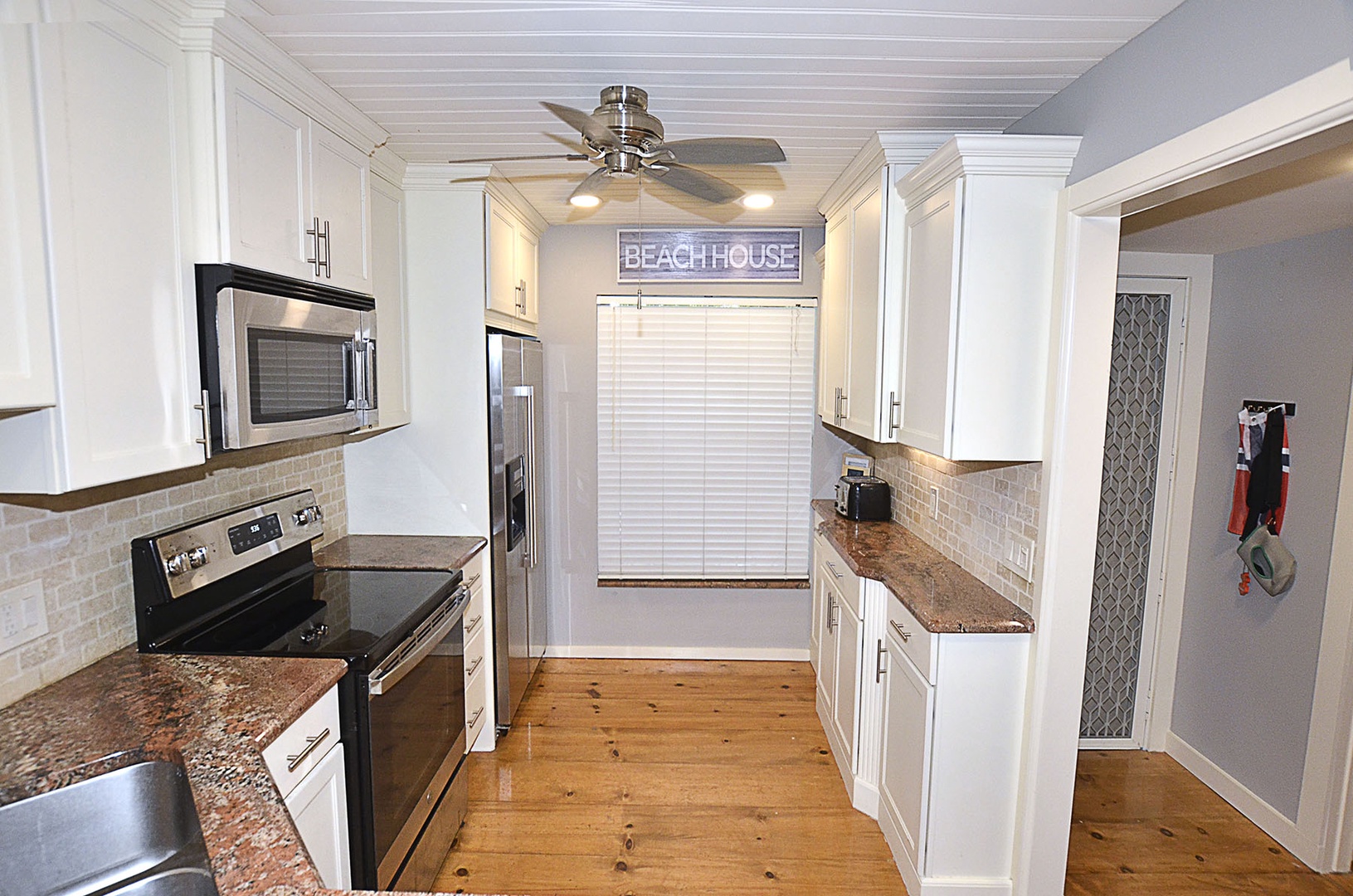 Kitchen. Cook your favorite meals in this bright, fully-equipped kitchen with granite counters, stainless appliances, and charming beach house details.