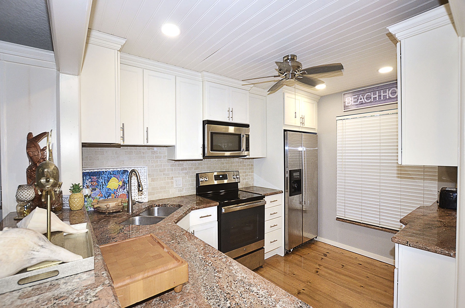 Kitchen. Your fully equipped kitchen features granite countertops, stainless appliances, and beach-themed touches that make meal prep feel like a coastal retreat.